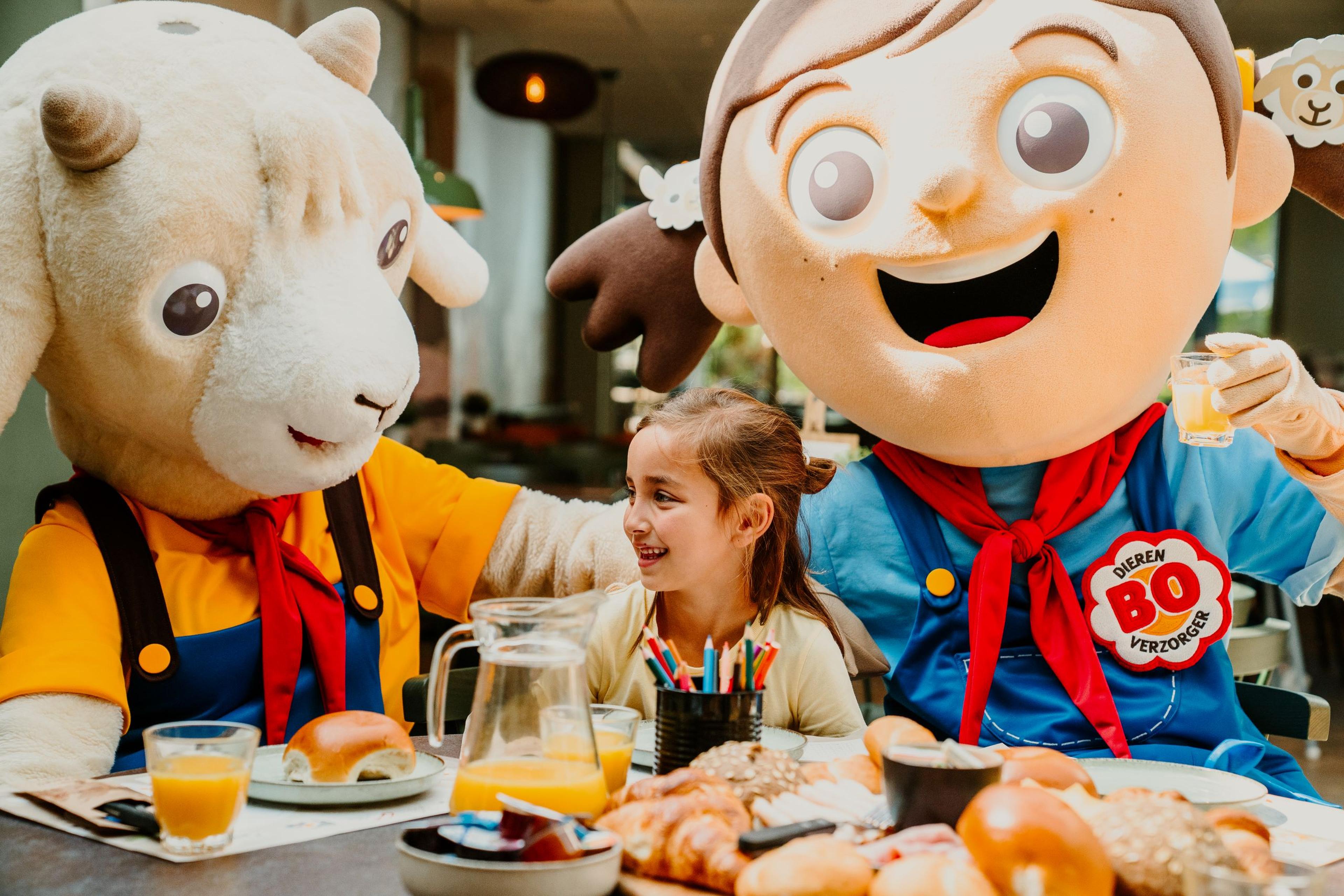 Een meisje geniet van het Bo en de Beestenbende ontbijt met mascottes Bo en Guus bij Vakantiepark Dierenbos.