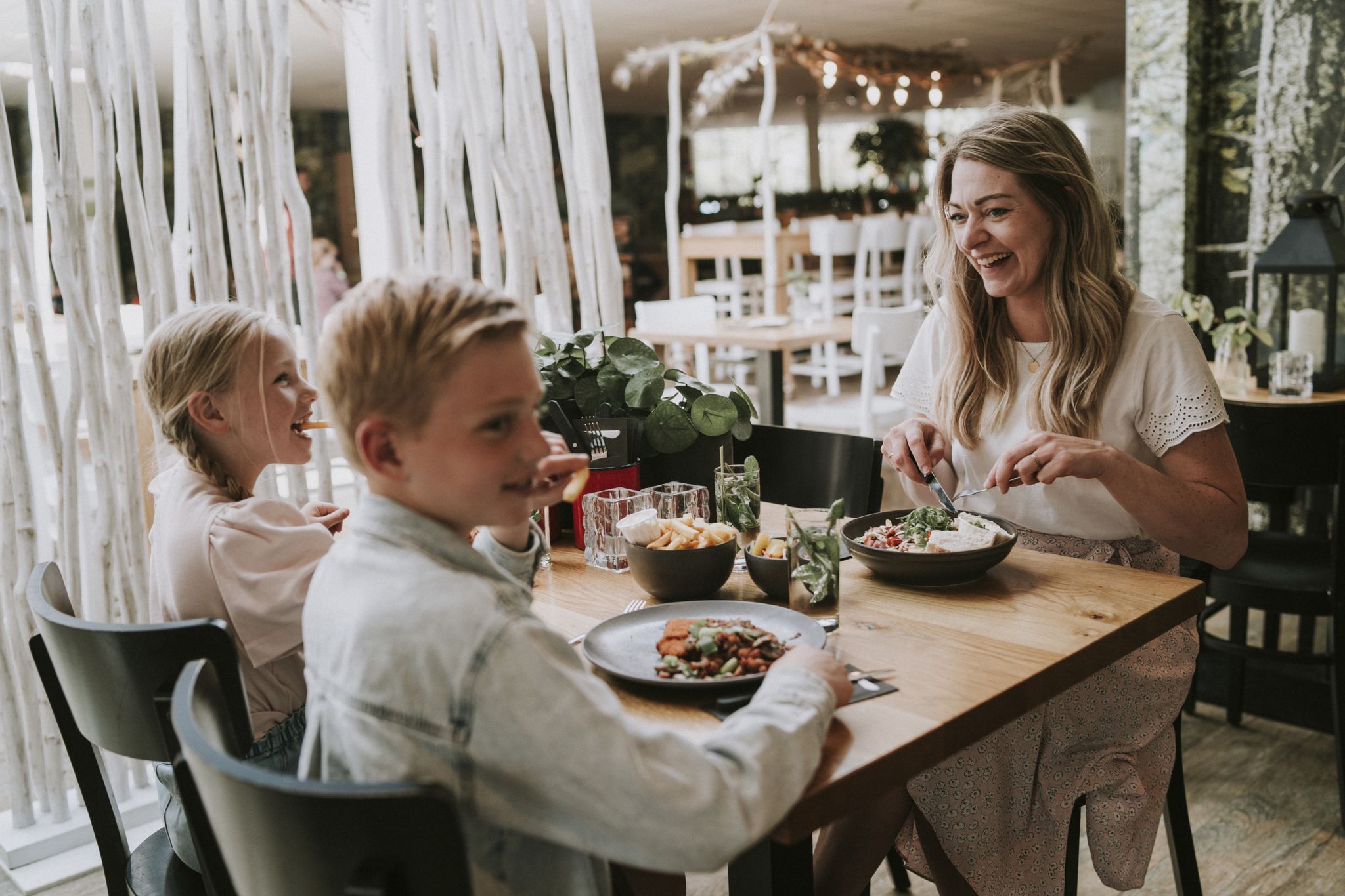Moeder en kinderen aan het lunchen in het restaurant bij Vakantiepark Dierenbos