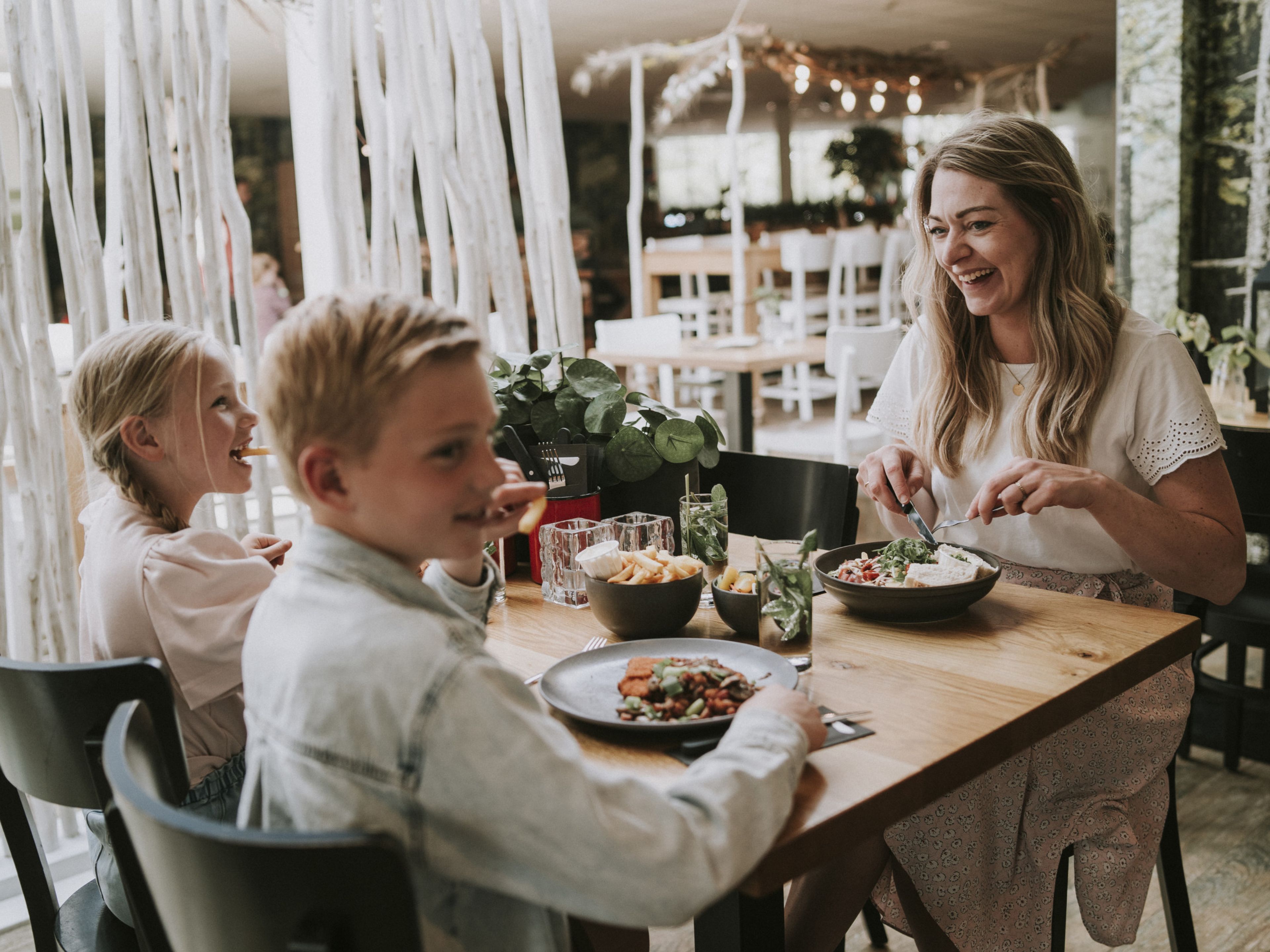 Moeder en kinderen aan het lunchen in het restaurant bij Vakantiepark Dierenbos