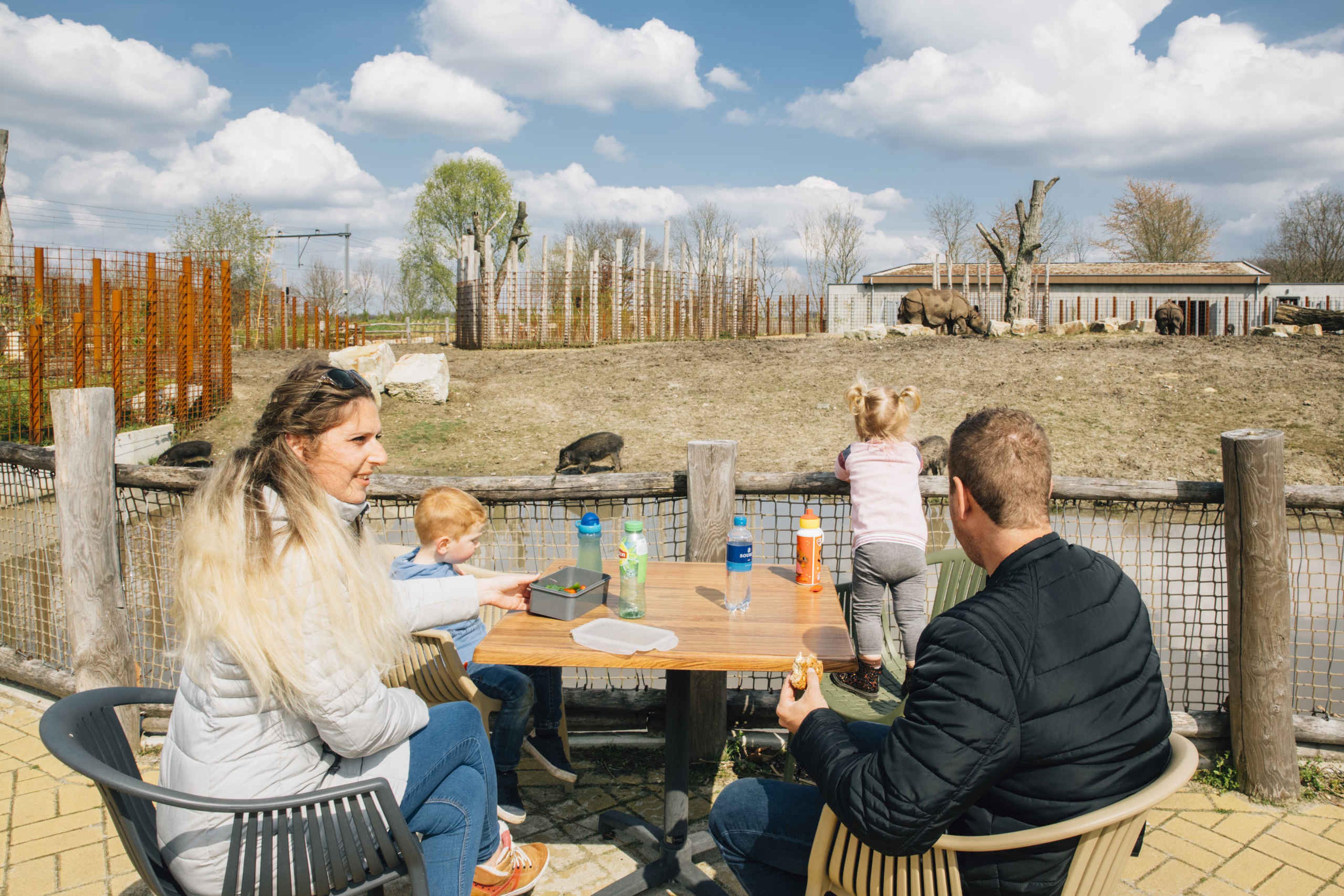 Gezin met eten en drinken op het terras de Halte in Eindhoven Zoo