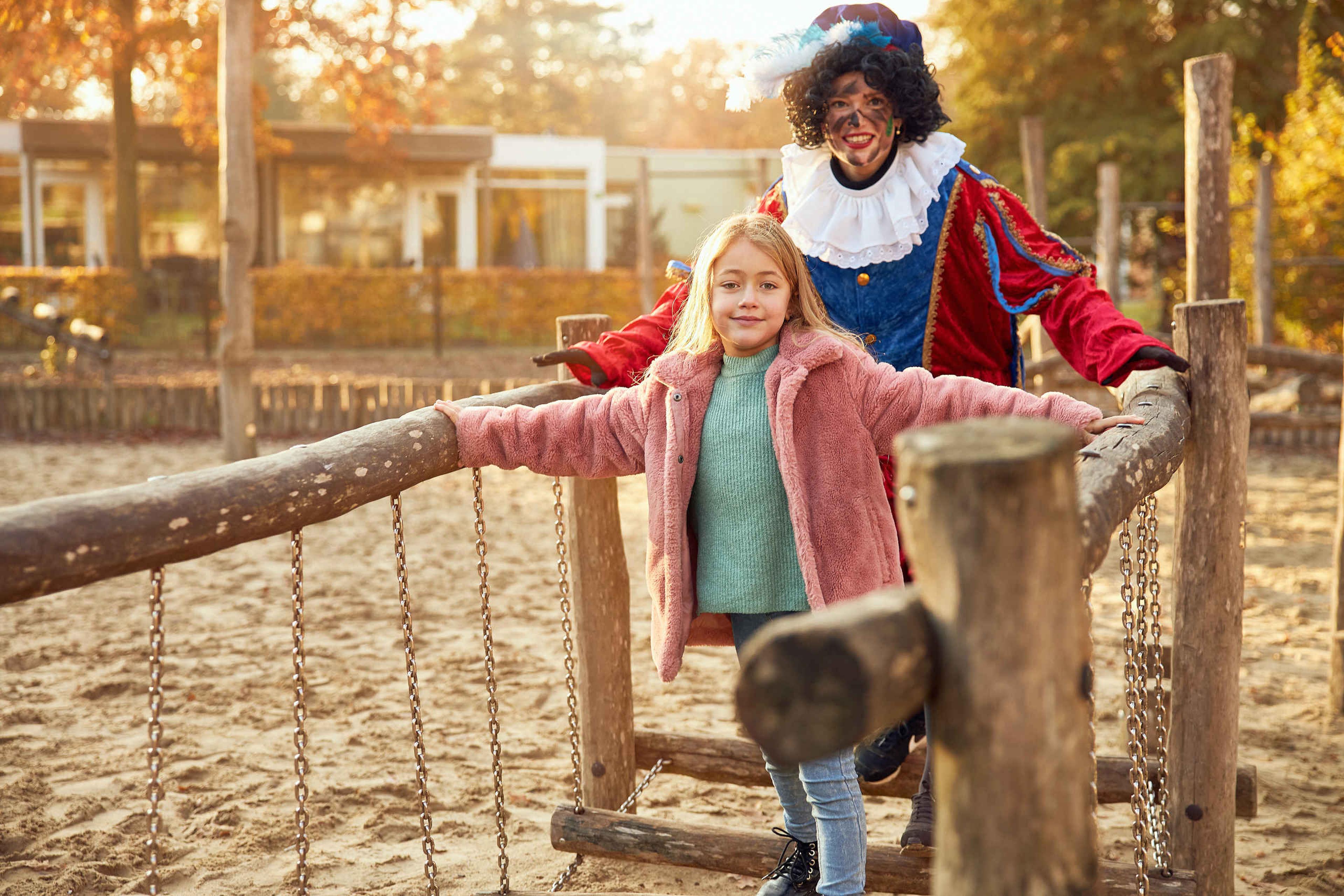 Kind en Piet spelen tijdens Sinterklaas samen in de speeltuin op Vakantiepark Dierenbos