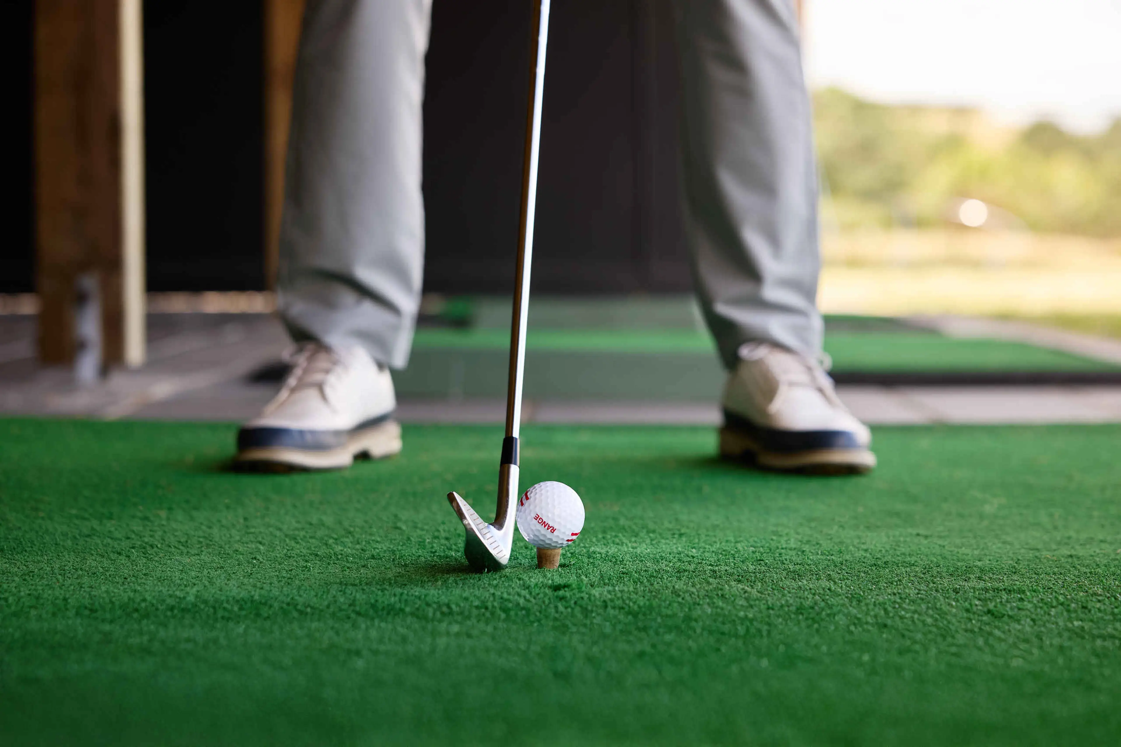 Een close-up van een golfbal en golfclub op de driving range van Golf De Gulbergen