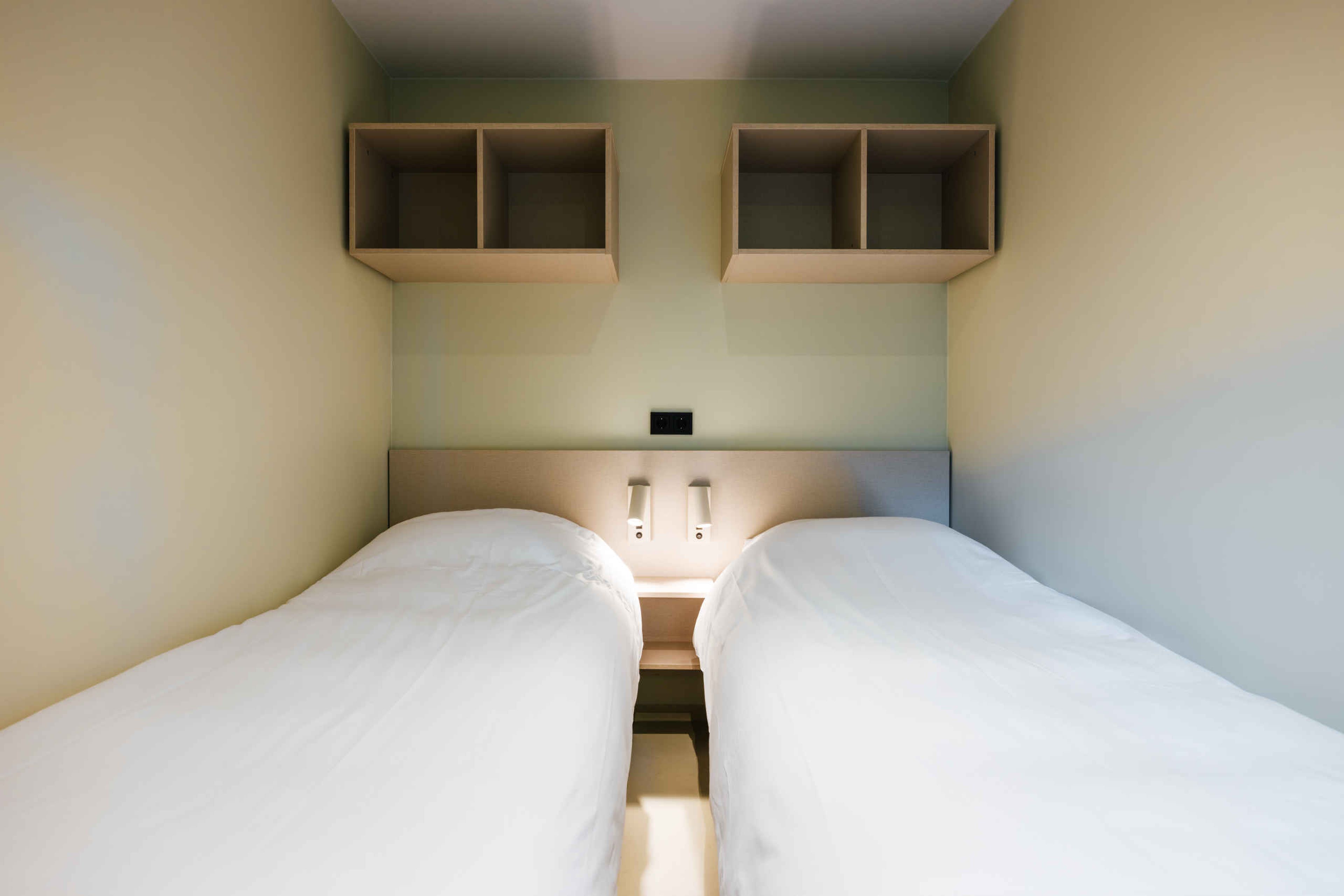 De slaapkamer met twee losse bedden in de Forest Jungalow op Lake Resort Beekse Bergen.