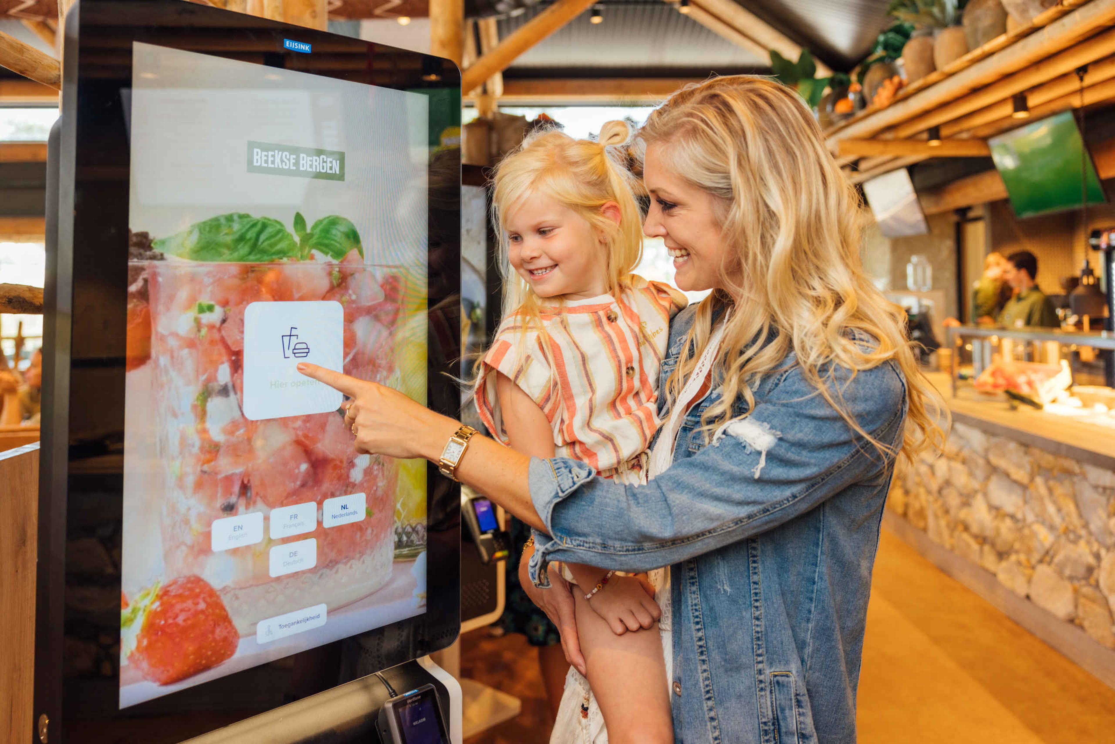 Moeder en dochter bij bestelzuil in restaurant Mugunda in Afrikadorp bij Safaripark Beekse Bergen