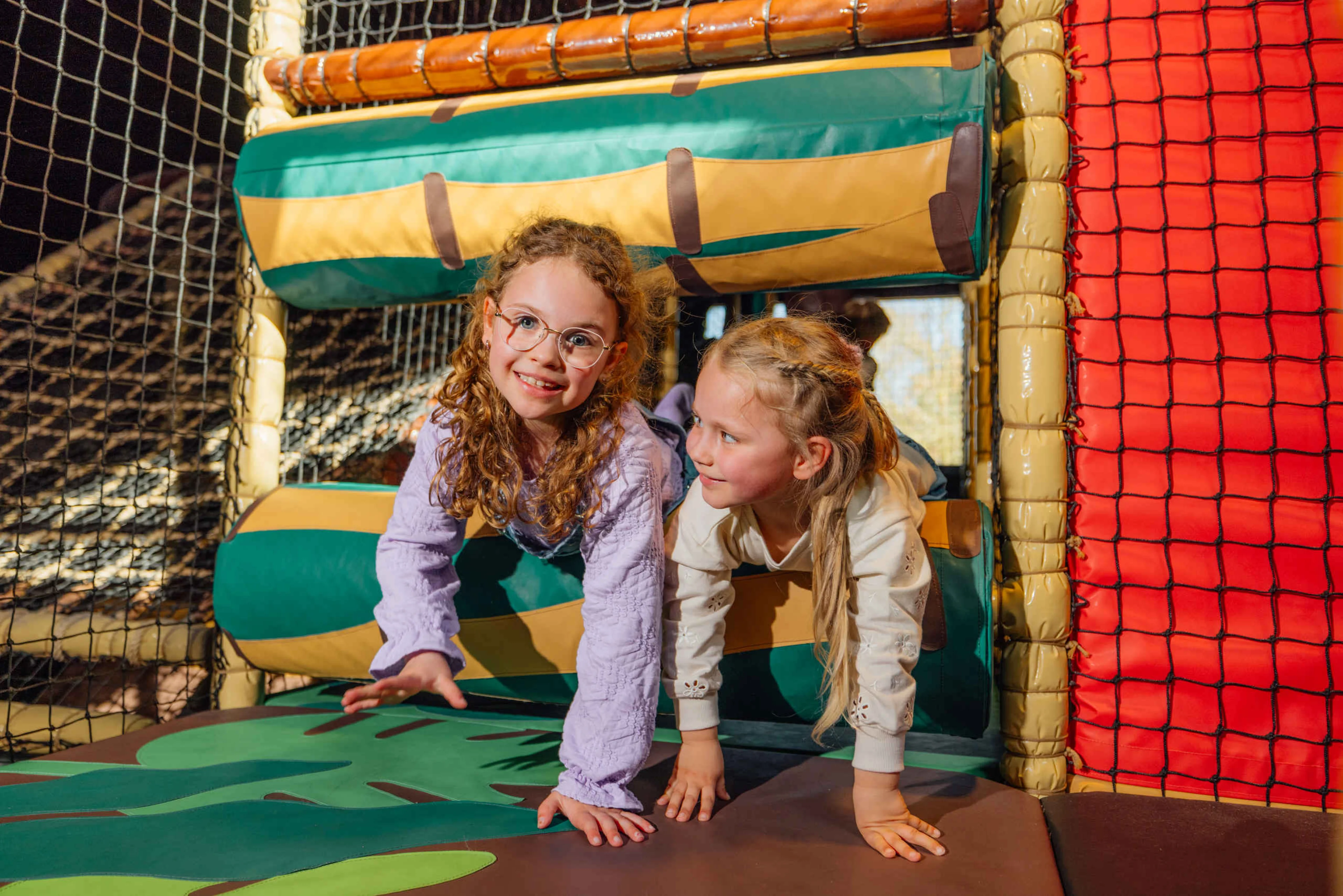 Twee kinderen klimmen door de klimtoestellen bij Speelland Indoor