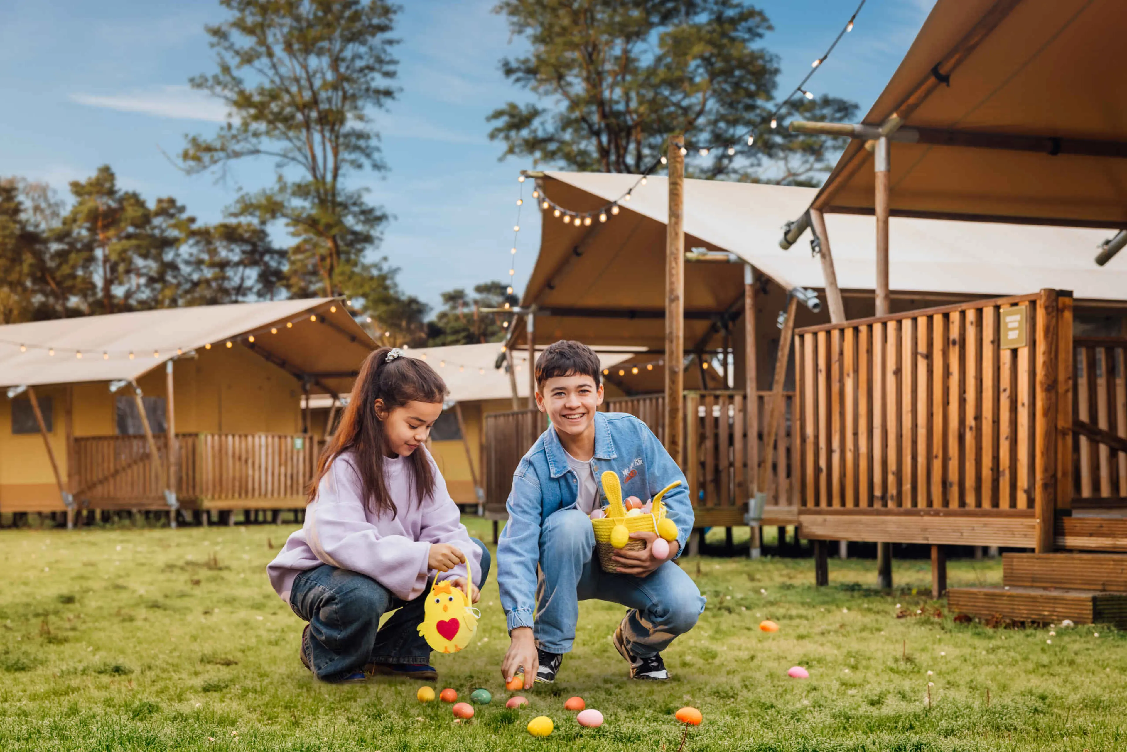 Twee kinderen zoeken paaseieren tijdens de paasvakantie op Lake Resort Beekse Bergen.