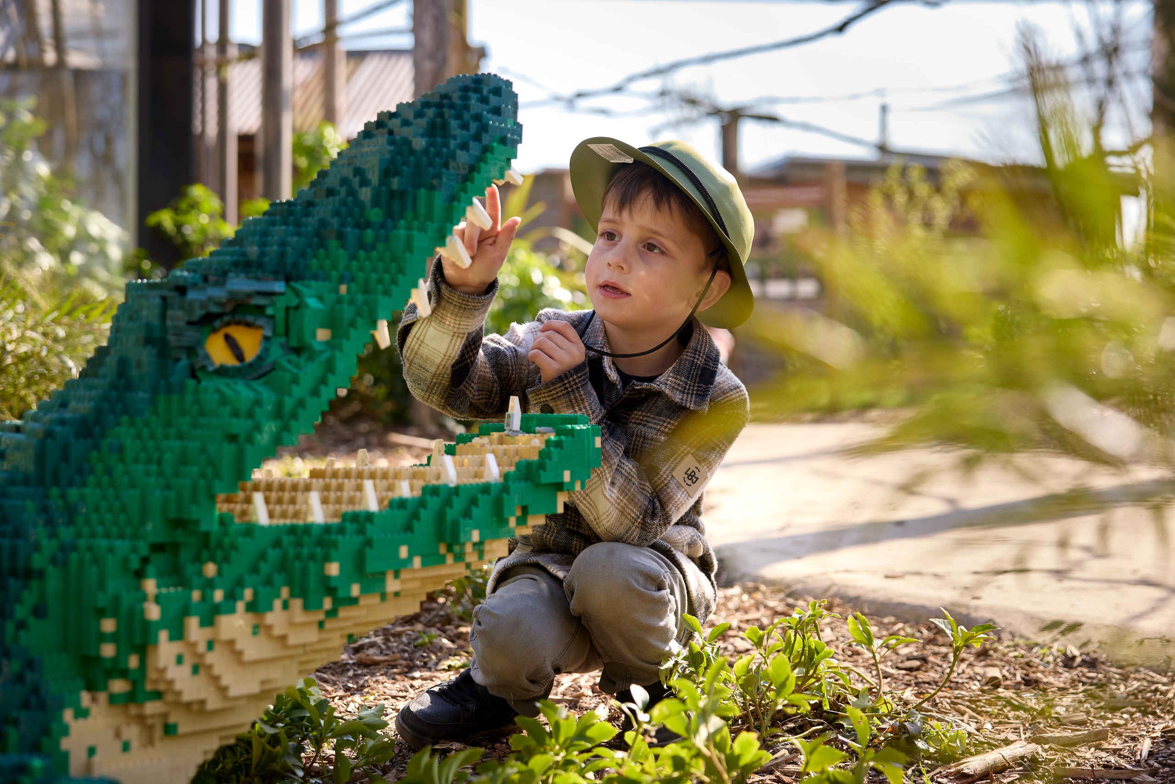 Een kind bekijkt een krokodil gemaakt van Lego tijdens Wild Bricks in ZooParc Overloon