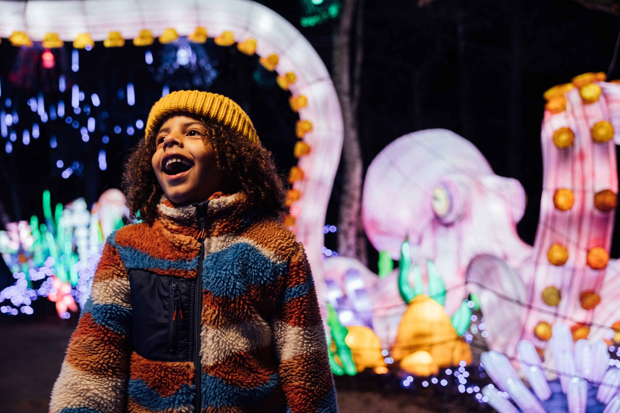 Een jongen lacht bij Light Safari Beekse Bergen.