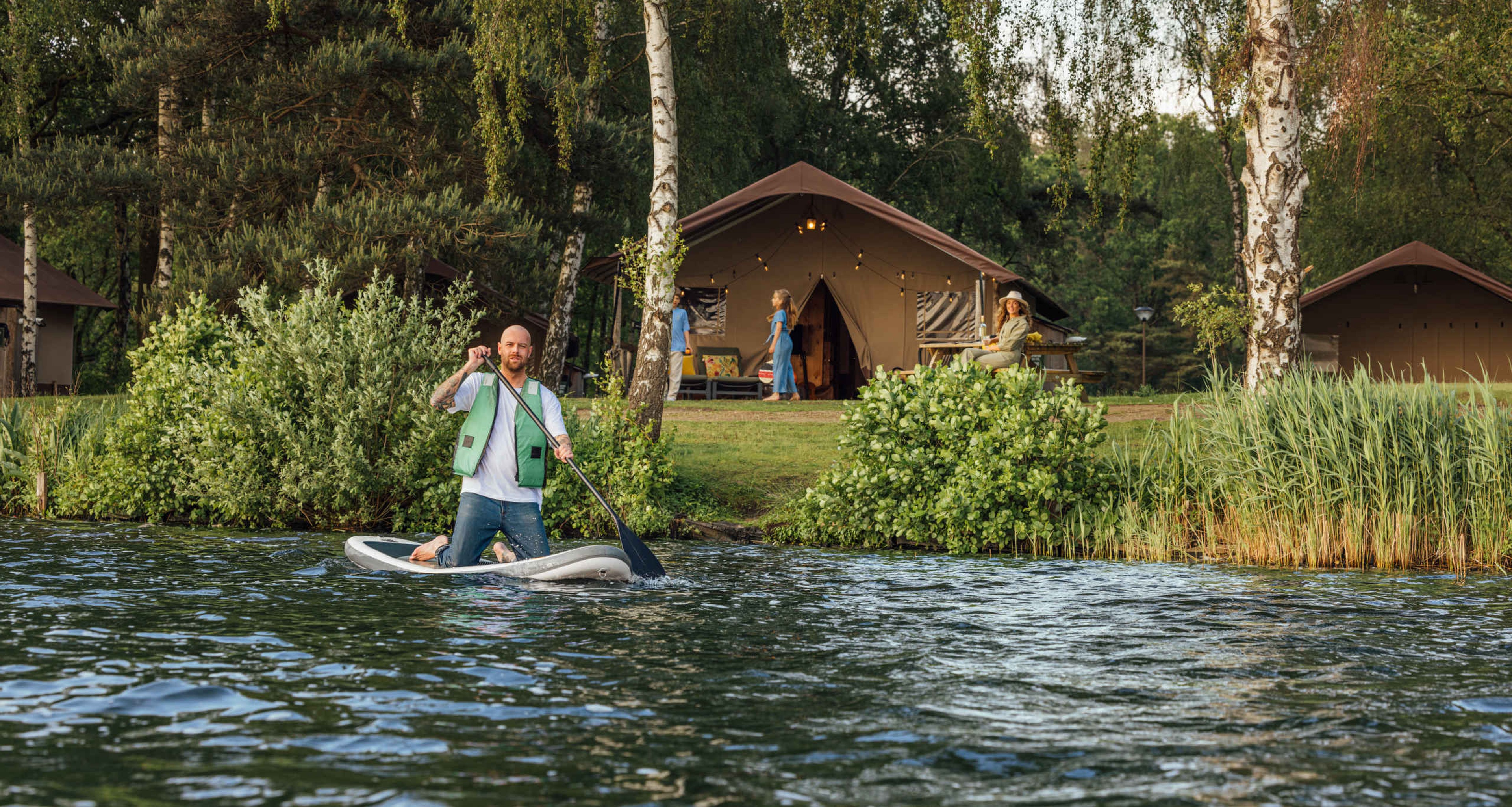 Man op een sup bij de Safaritenten op Lake Resort Beekse Bergen