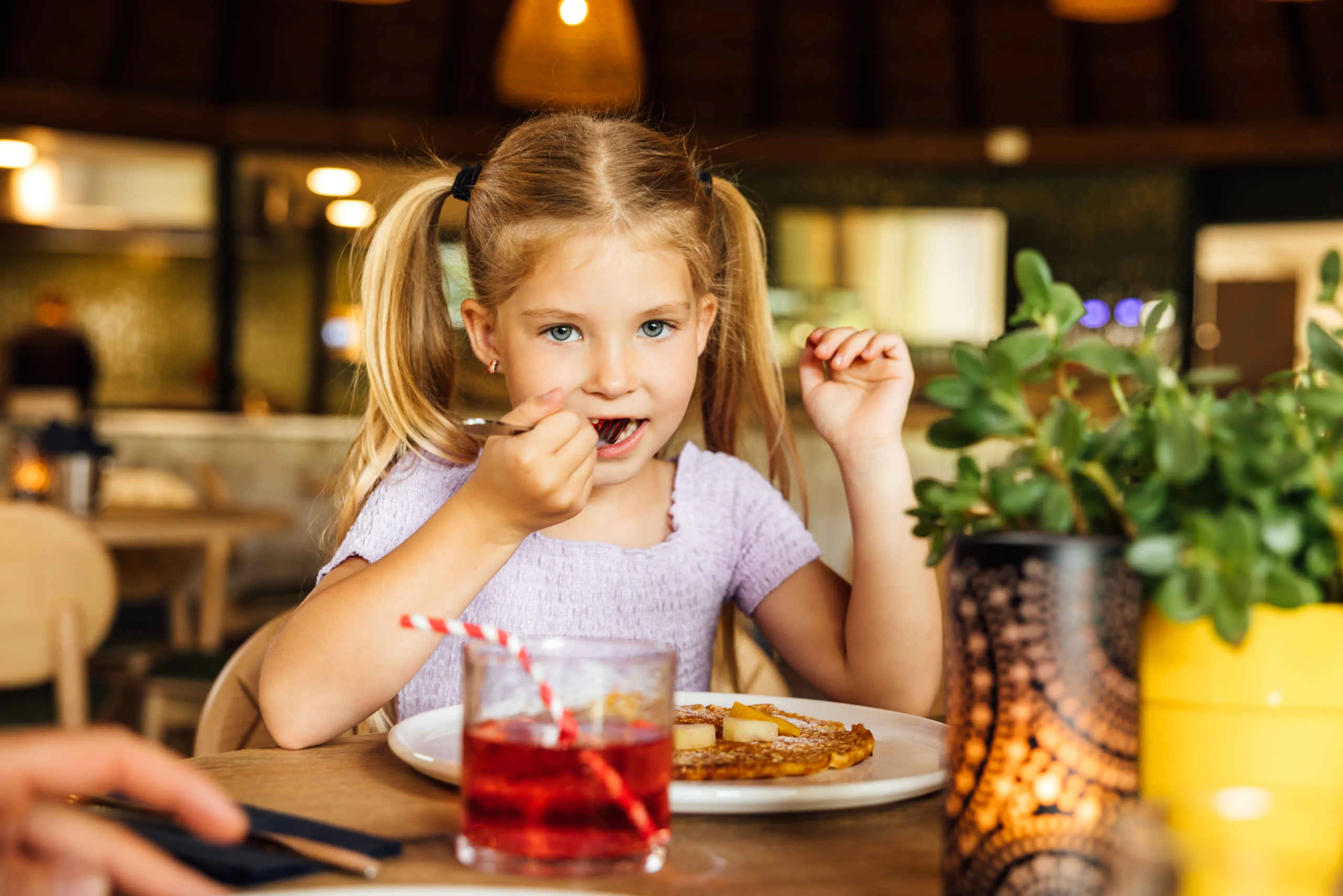 Meisje eet pannenkoek in Wanyama in Safaripark Beekse Bergen