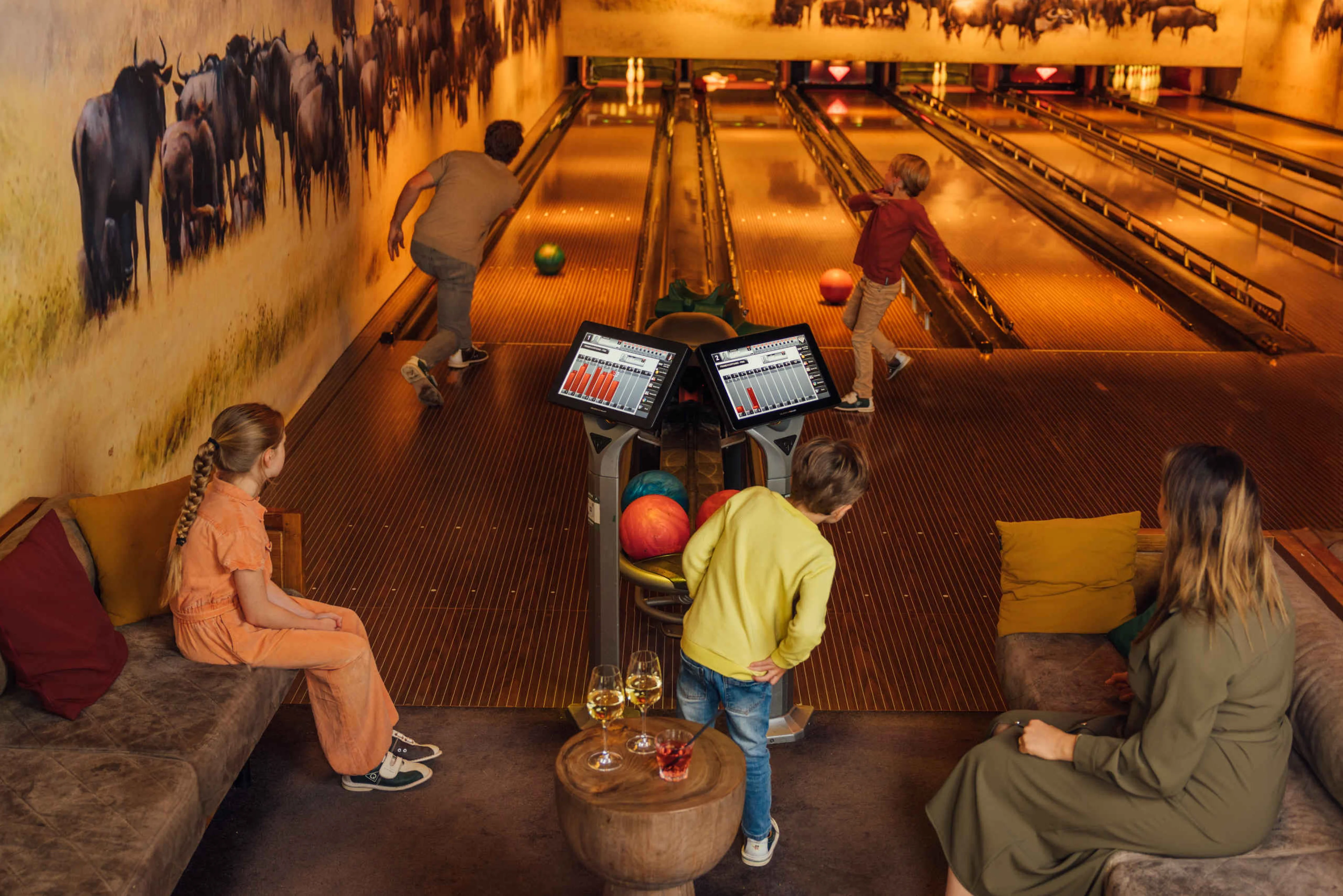 Gezin aan het bowlen in Pamoja Lounge Karibu Town op Safari Resort Beekse Bergen