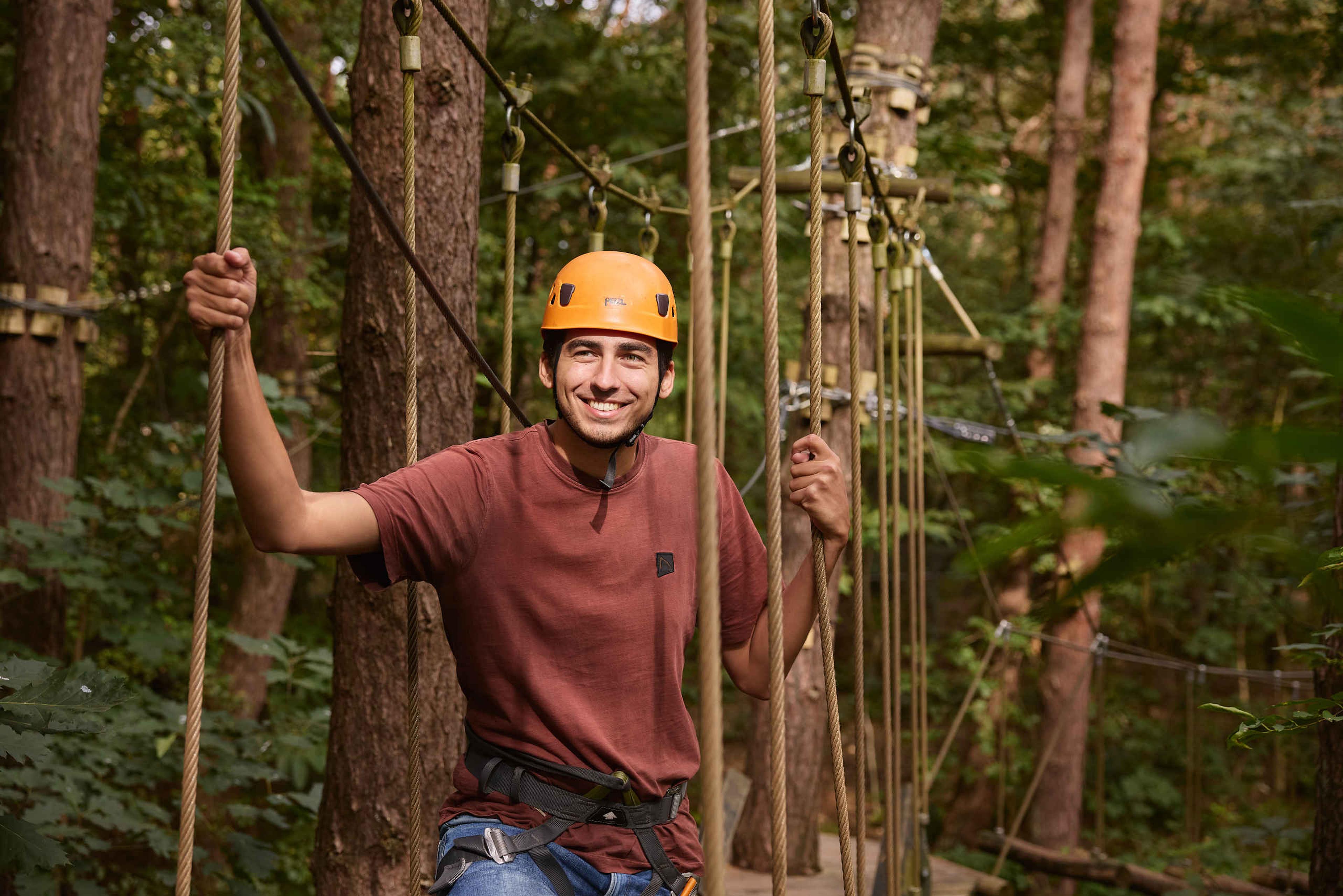 Een man tijdens het klimmen op het klimparcours van Klimrijk Brabant