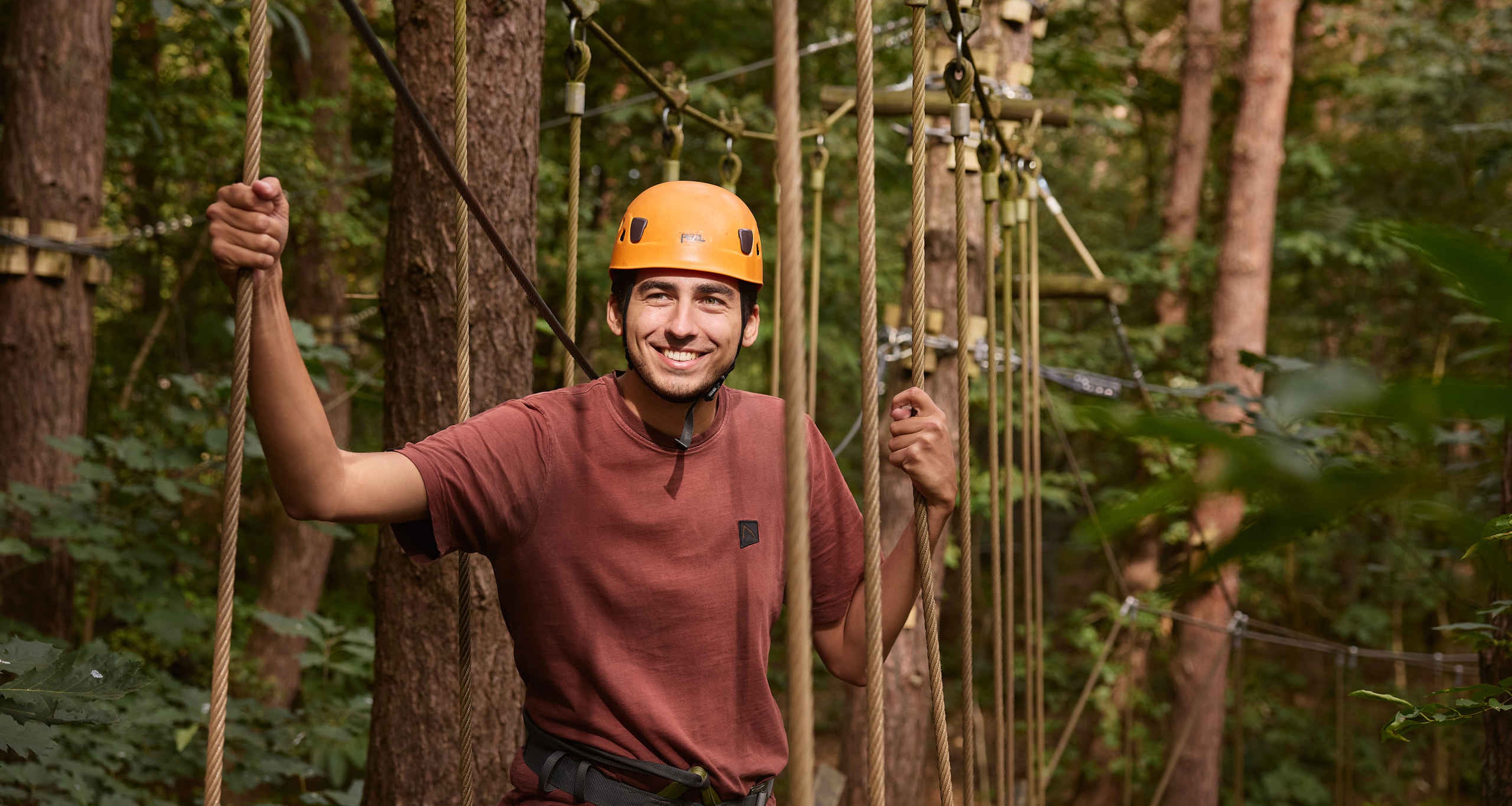 Een man tijdens het klimmen op het klimparcours van Klimrijk Brabant