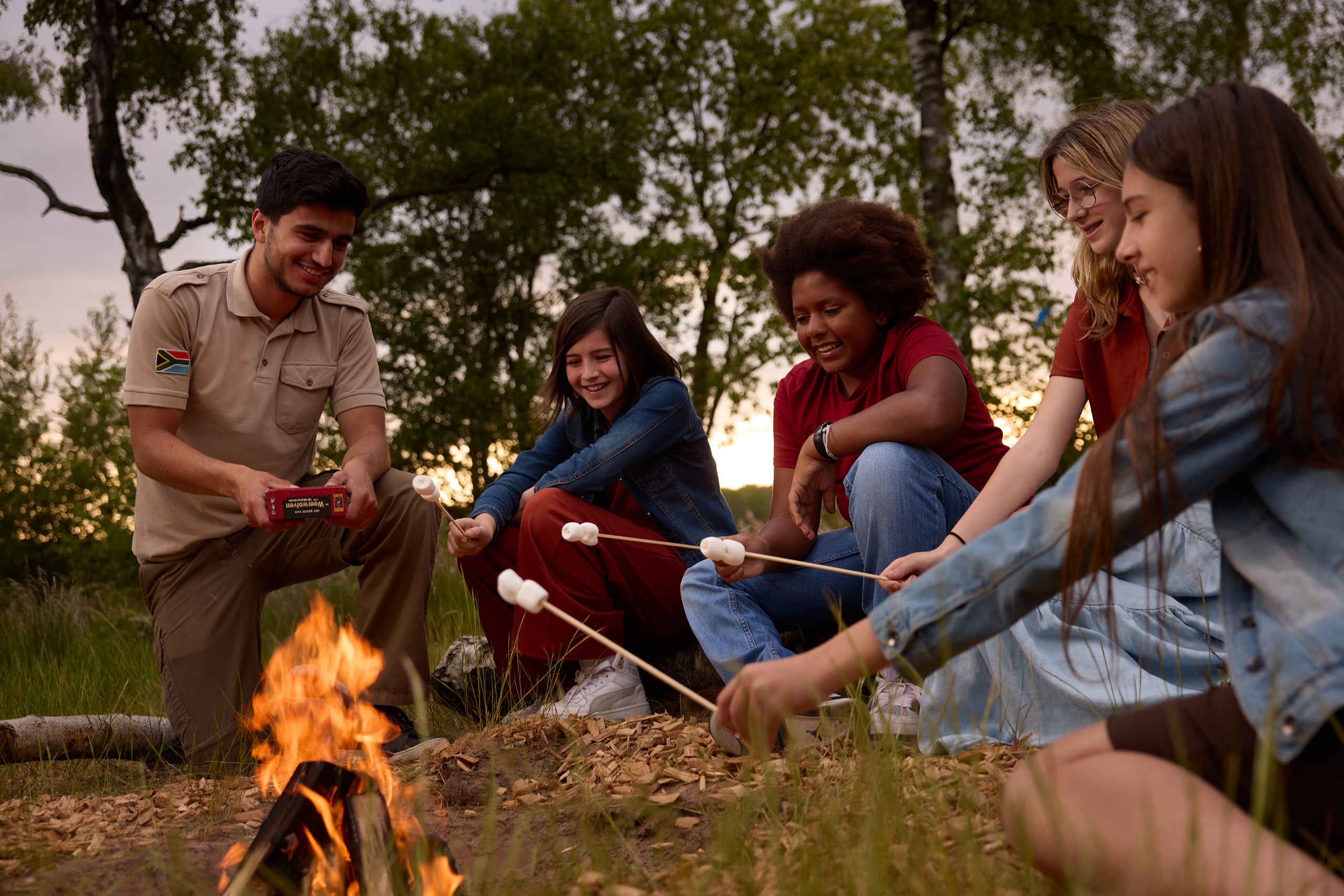 Kinderen en tieners met een ranger bij het kampvuur op Lake Resort Beekse Bergen