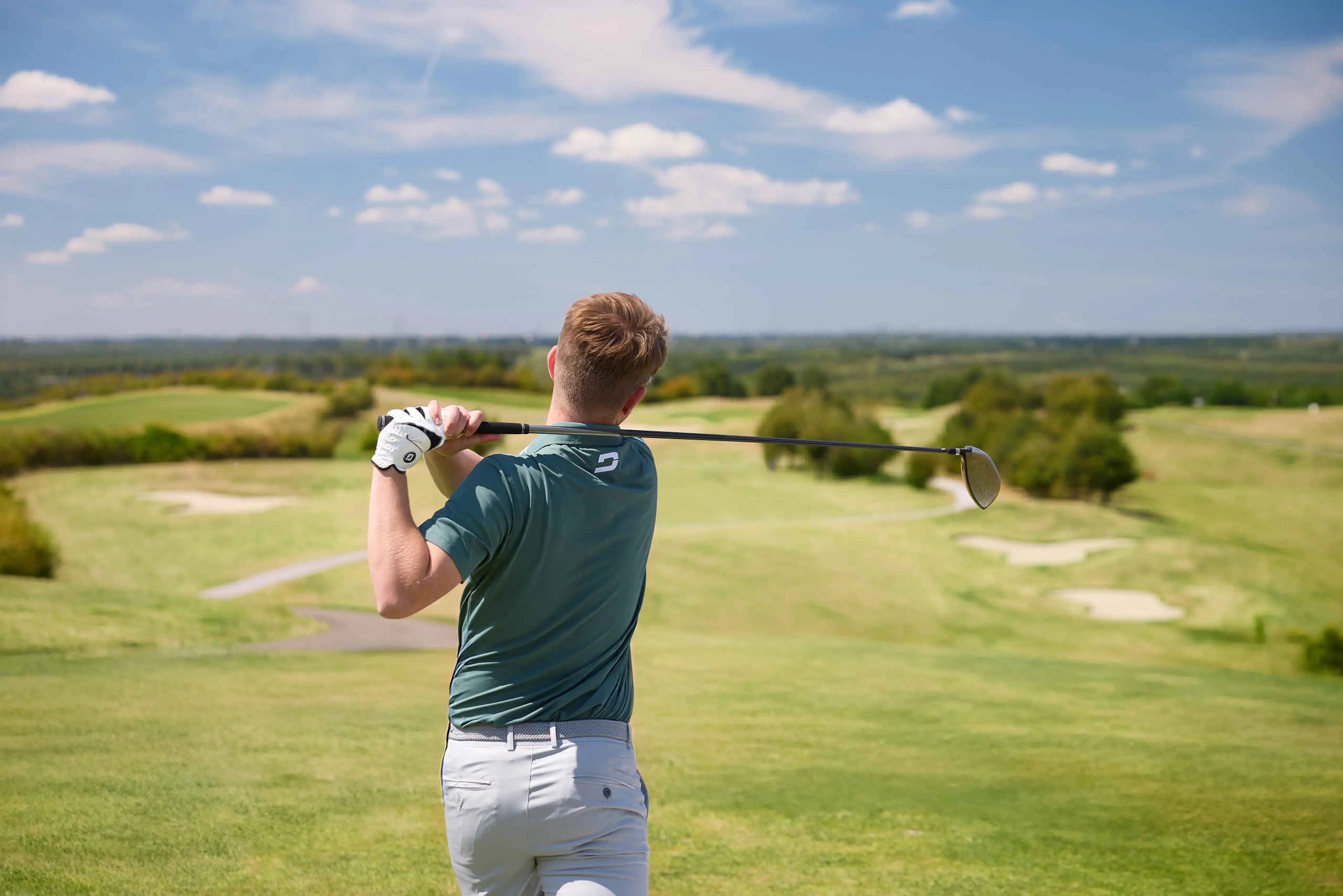 Een man slaat af met zijn driver op de sprookjesbaan van Golf De Gulbergen