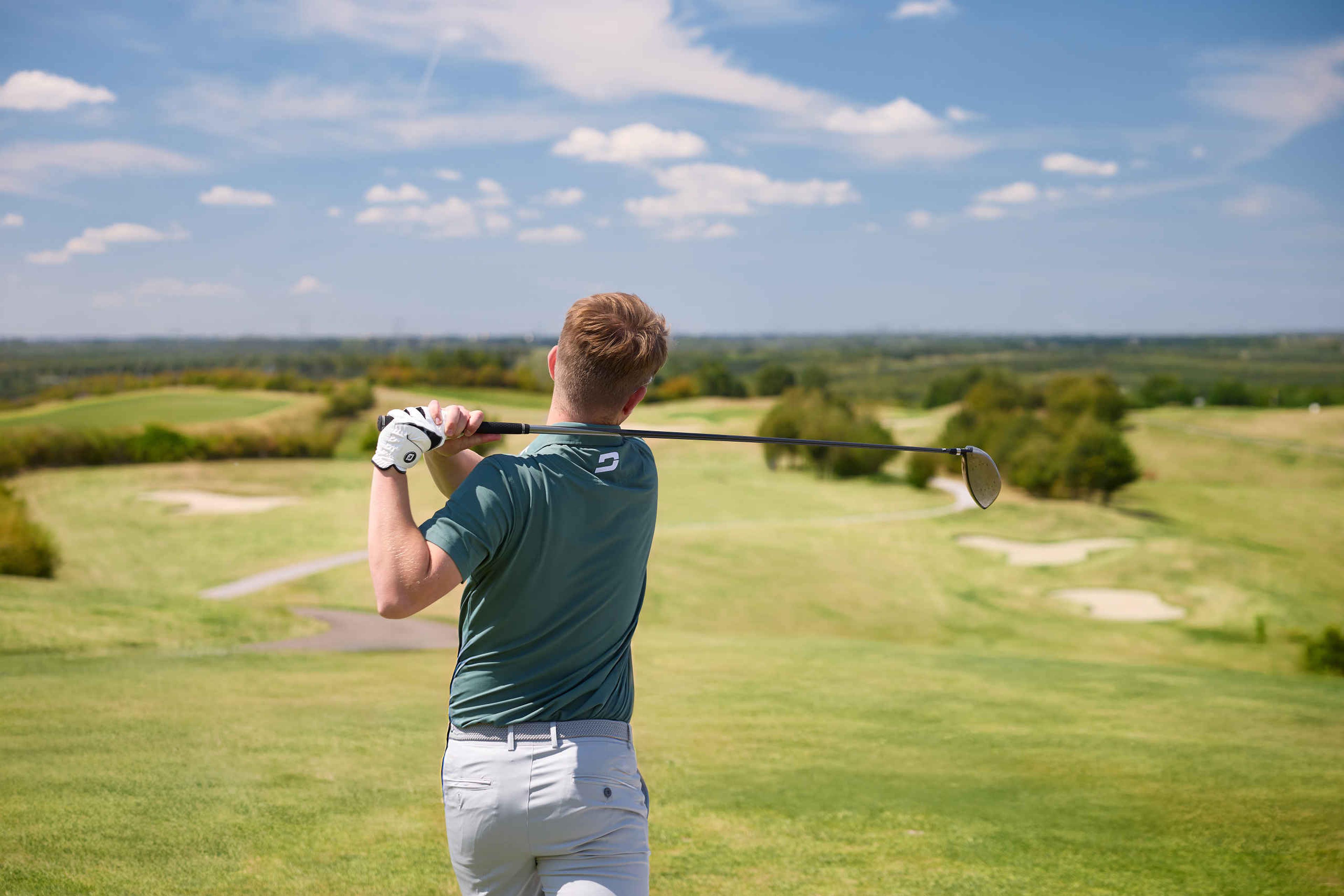 Een man slaat af met zijn driver op de sprookjesbaan van Golf De Gulbergen