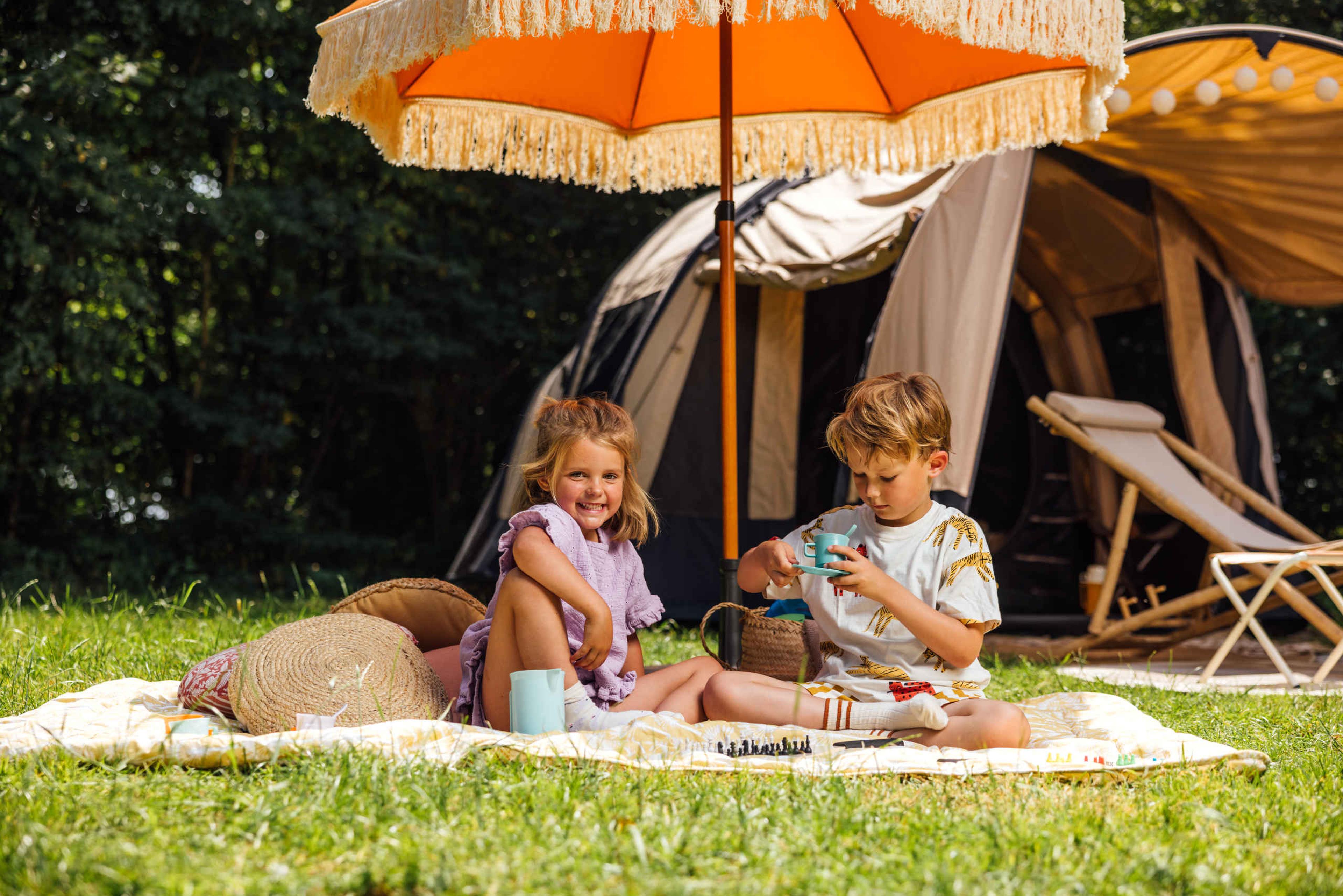 Twee kinderen spelen op de kampeerplek op de camping van Lake Resort Beekse Bergen.
