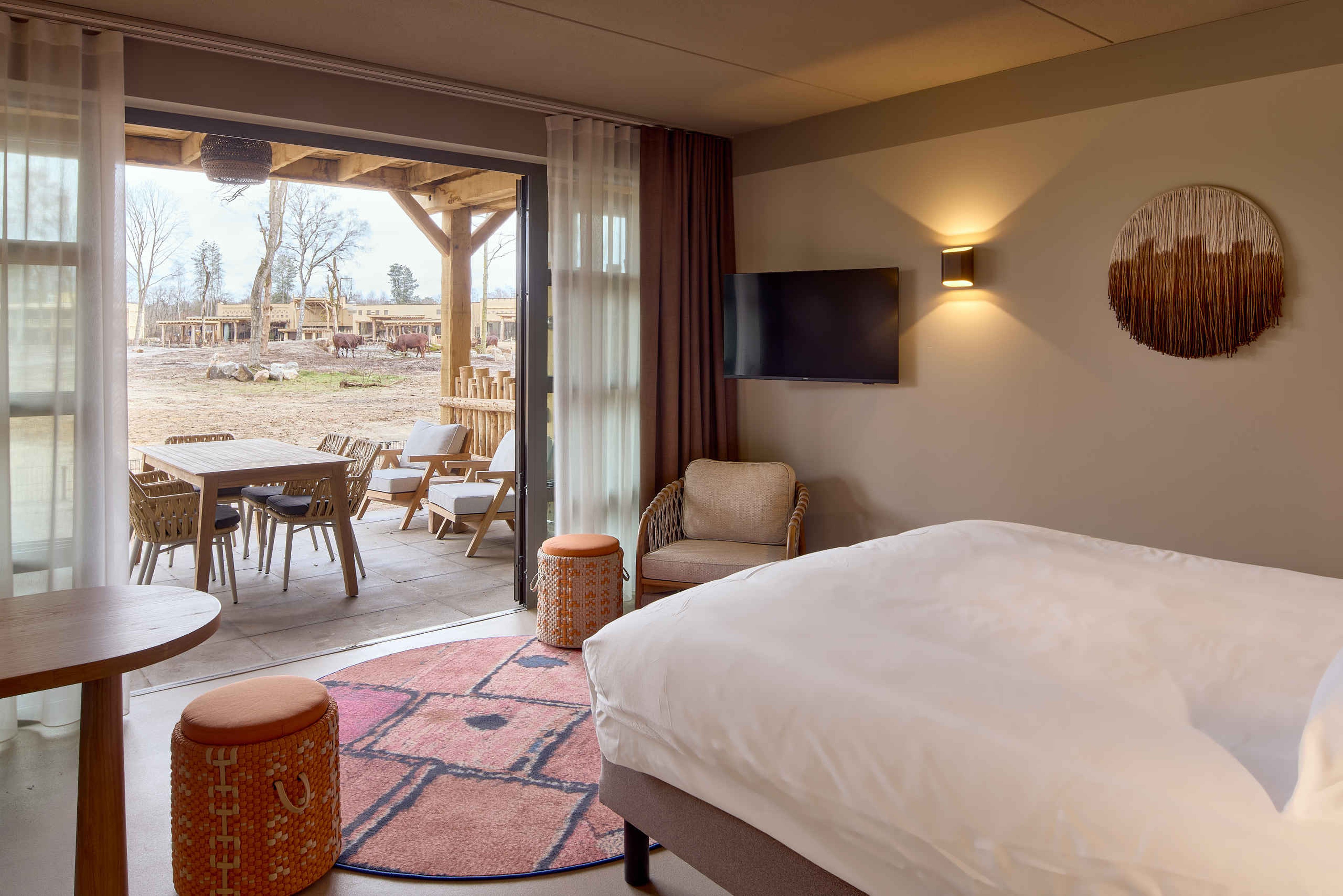 Een savanne room met uitzicht op de savanne van Safari Hotel Beekse Bergen, waar je kan overnachten na je bezoek aan Bar & Restaurant Nommos.
