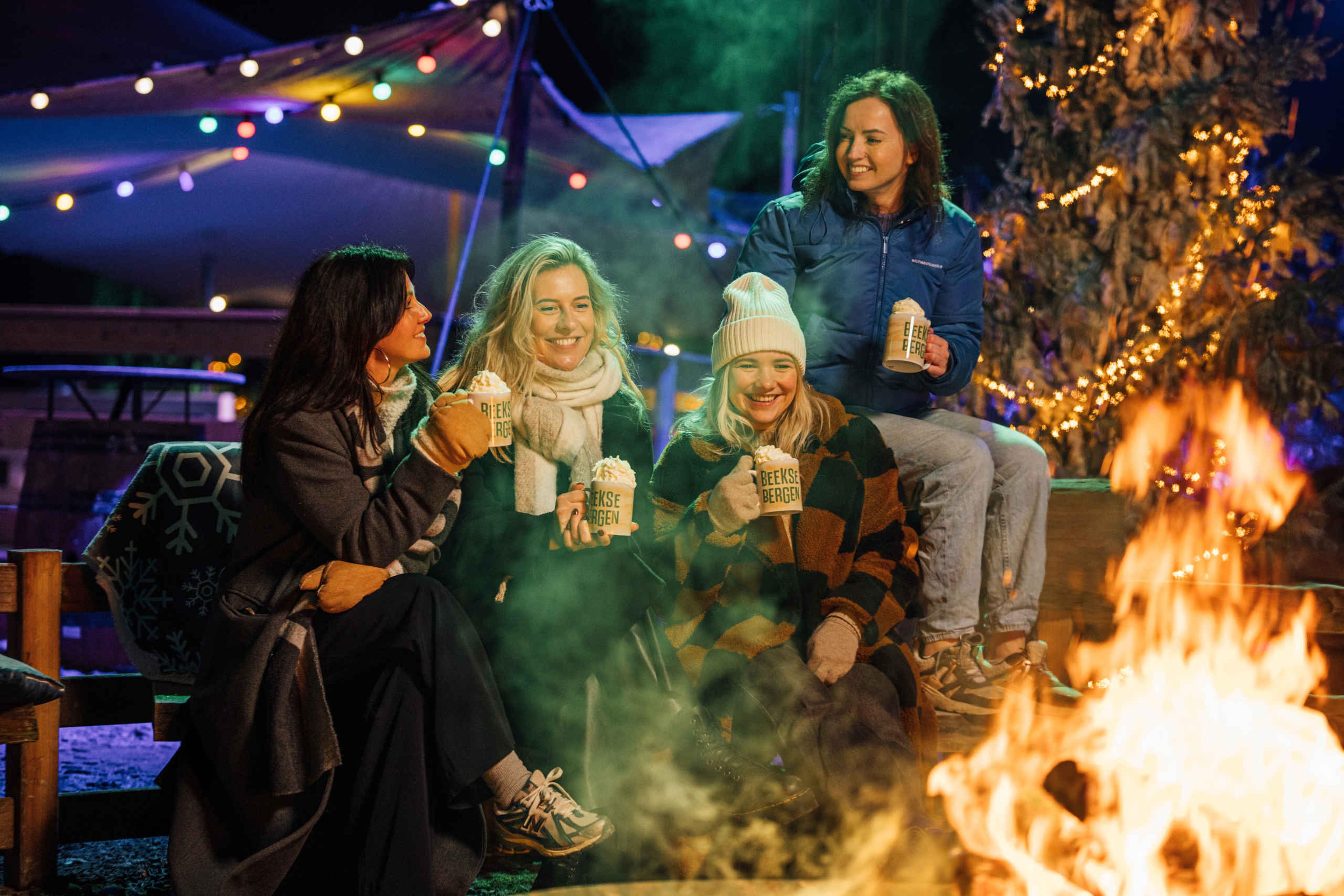 Groep vrouwen bij het kampvuur in Safaripark Beekse Bergen tijdens Light Safari