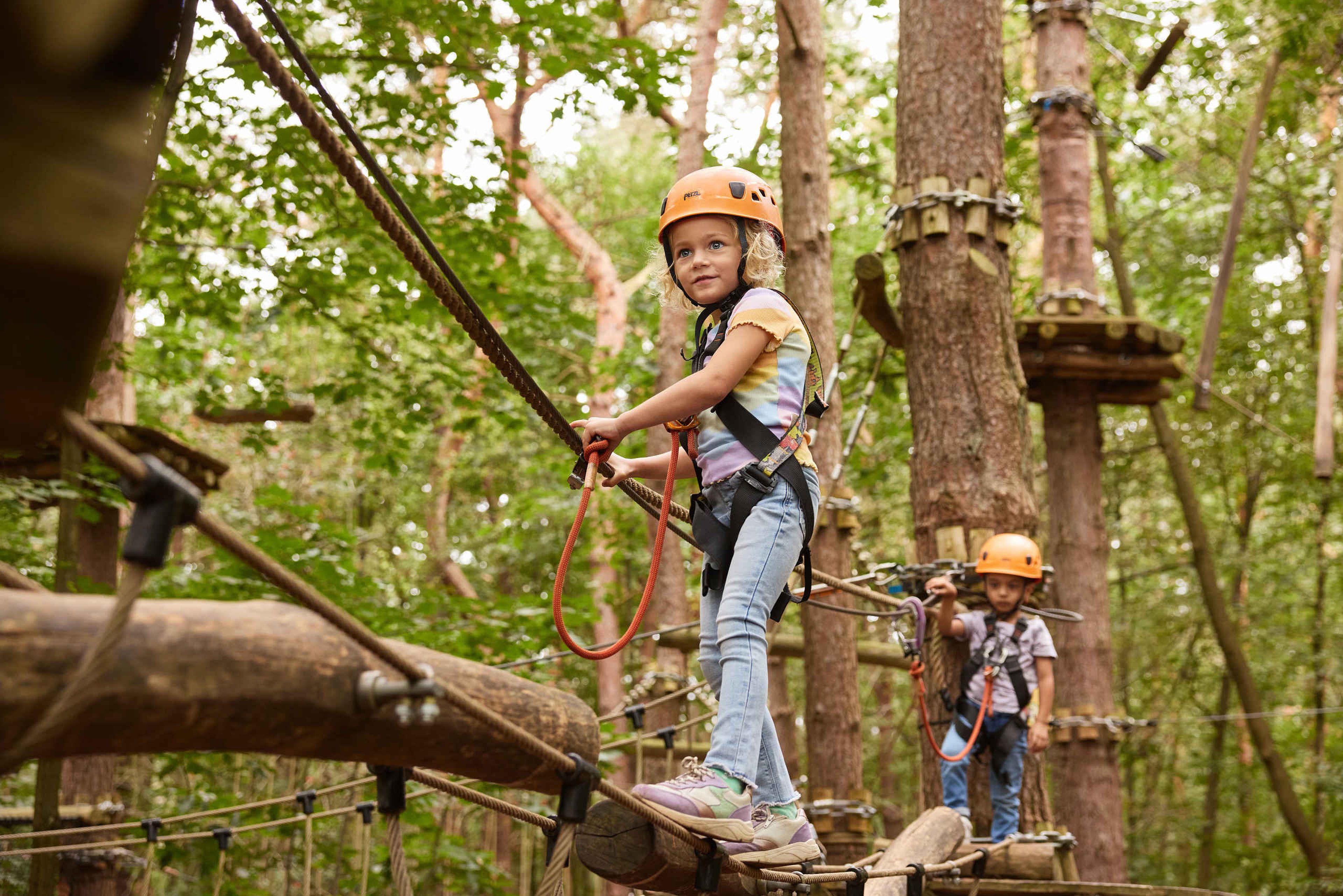Een meisje en een jongen klimmen op het pico parcours.