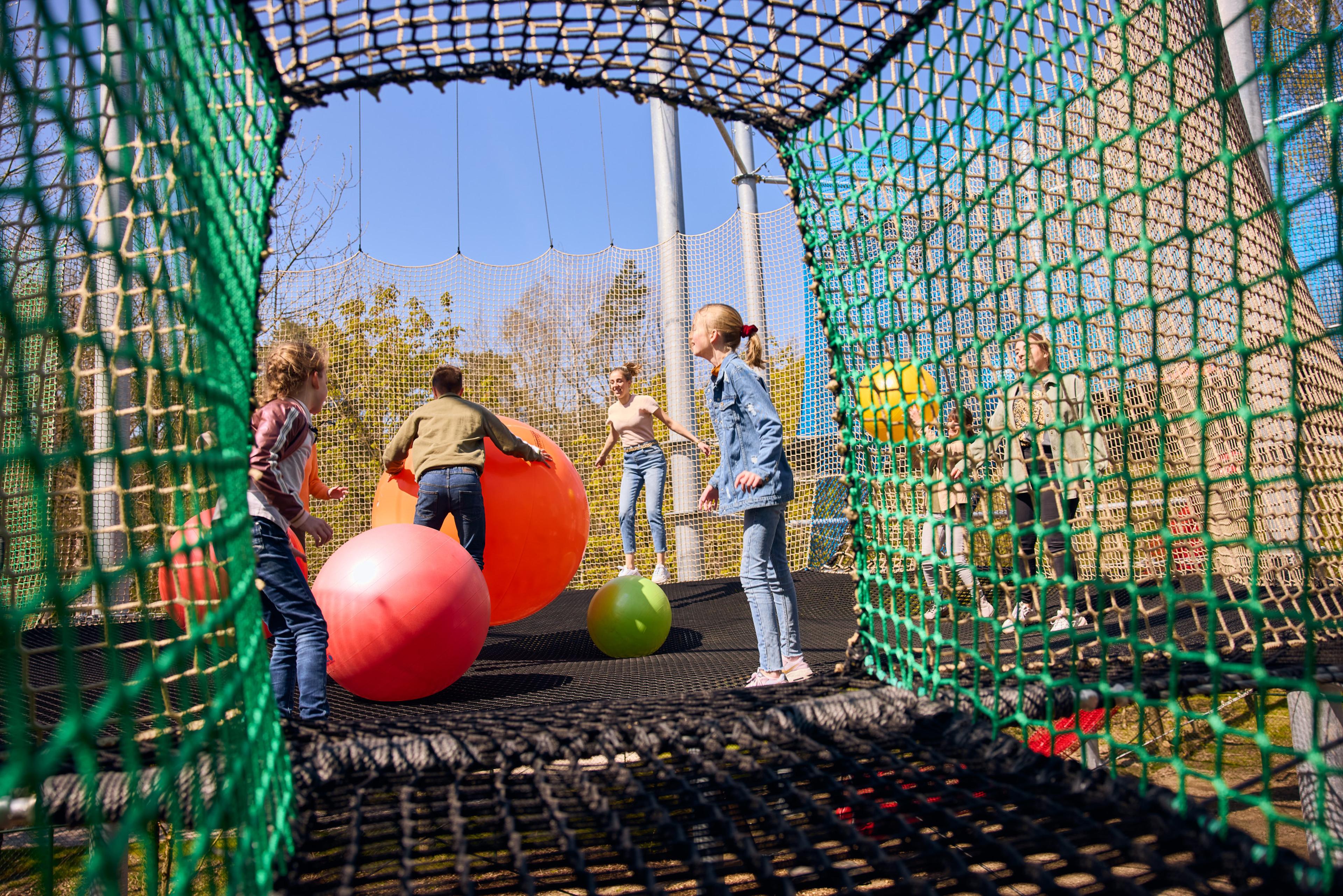 Kinderen spelen met ballen in het Netten Adventure bij Klimrijk Brabant