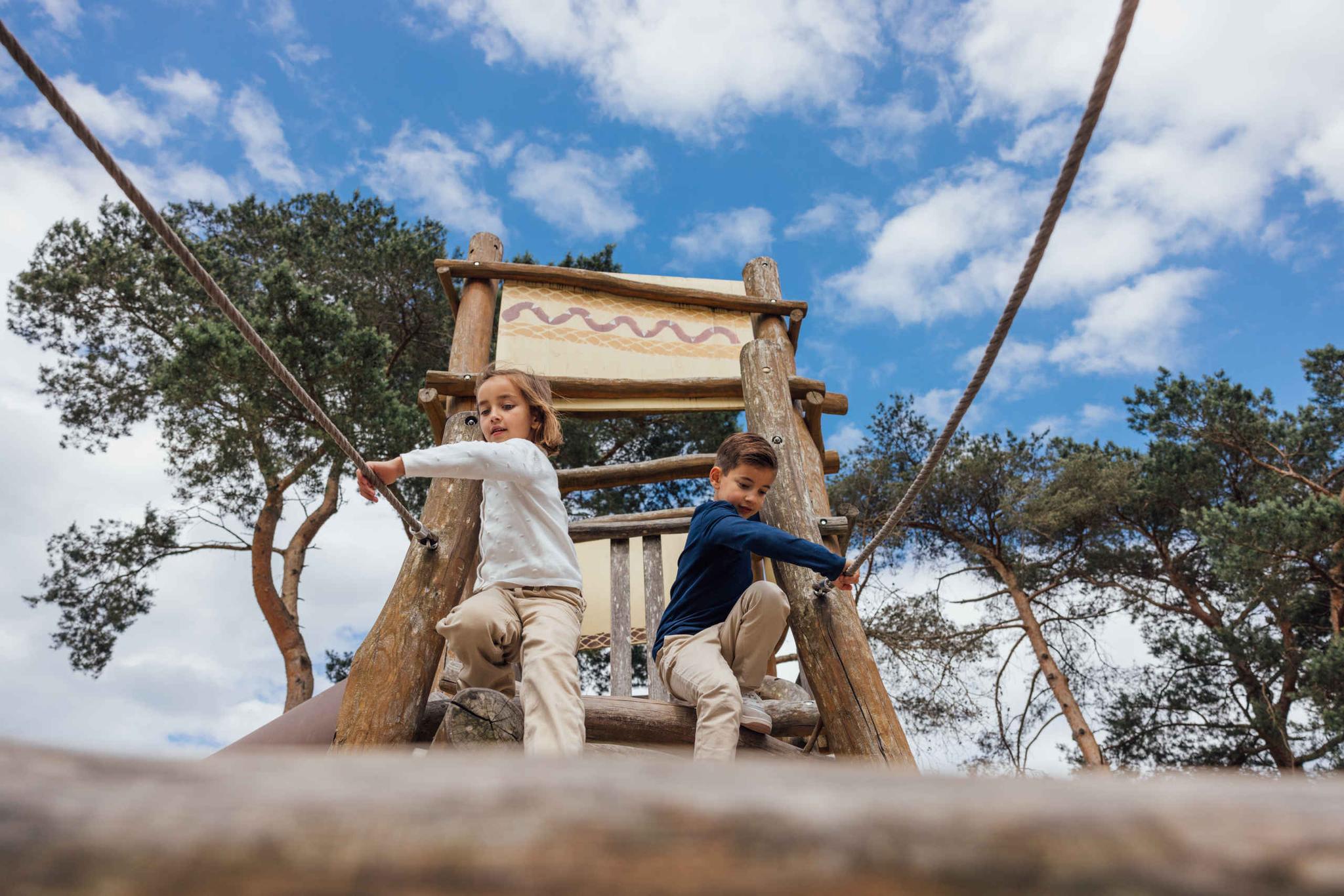 Lente kinderen spelen in de speeltuin op het klimrek van Karibu Town in Lake Resort Beekse Bergen