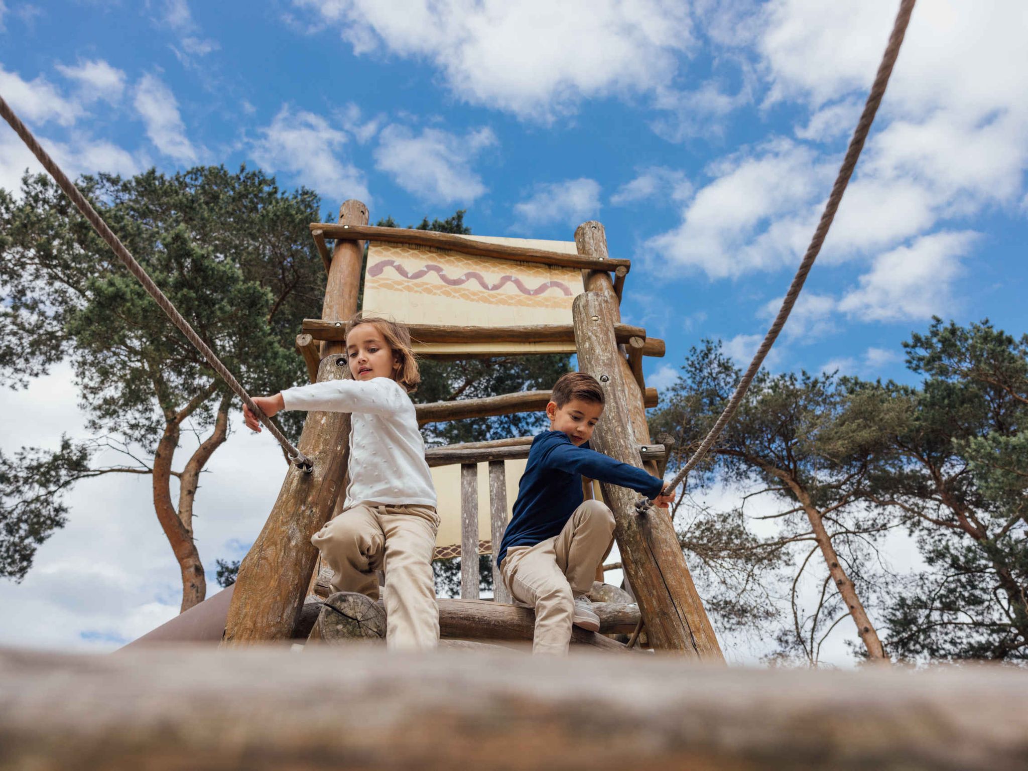 Lente kinderen spelen in de speeltuin op het klimrek van Karibu Town in Lake Resort Beekse Bergen