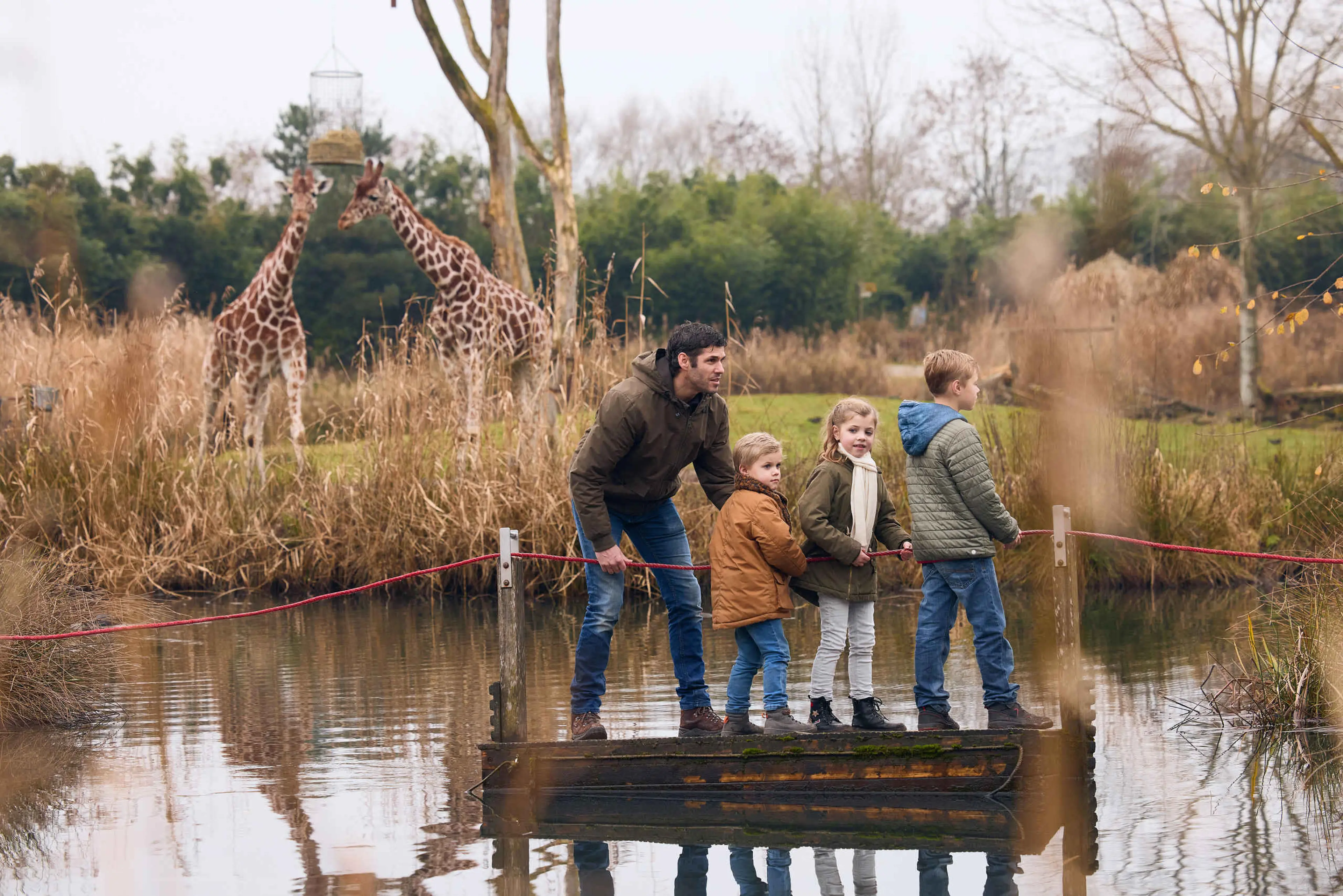 Herfst vader met kinderen op vlot bij Giraffen ZooParc Overloon