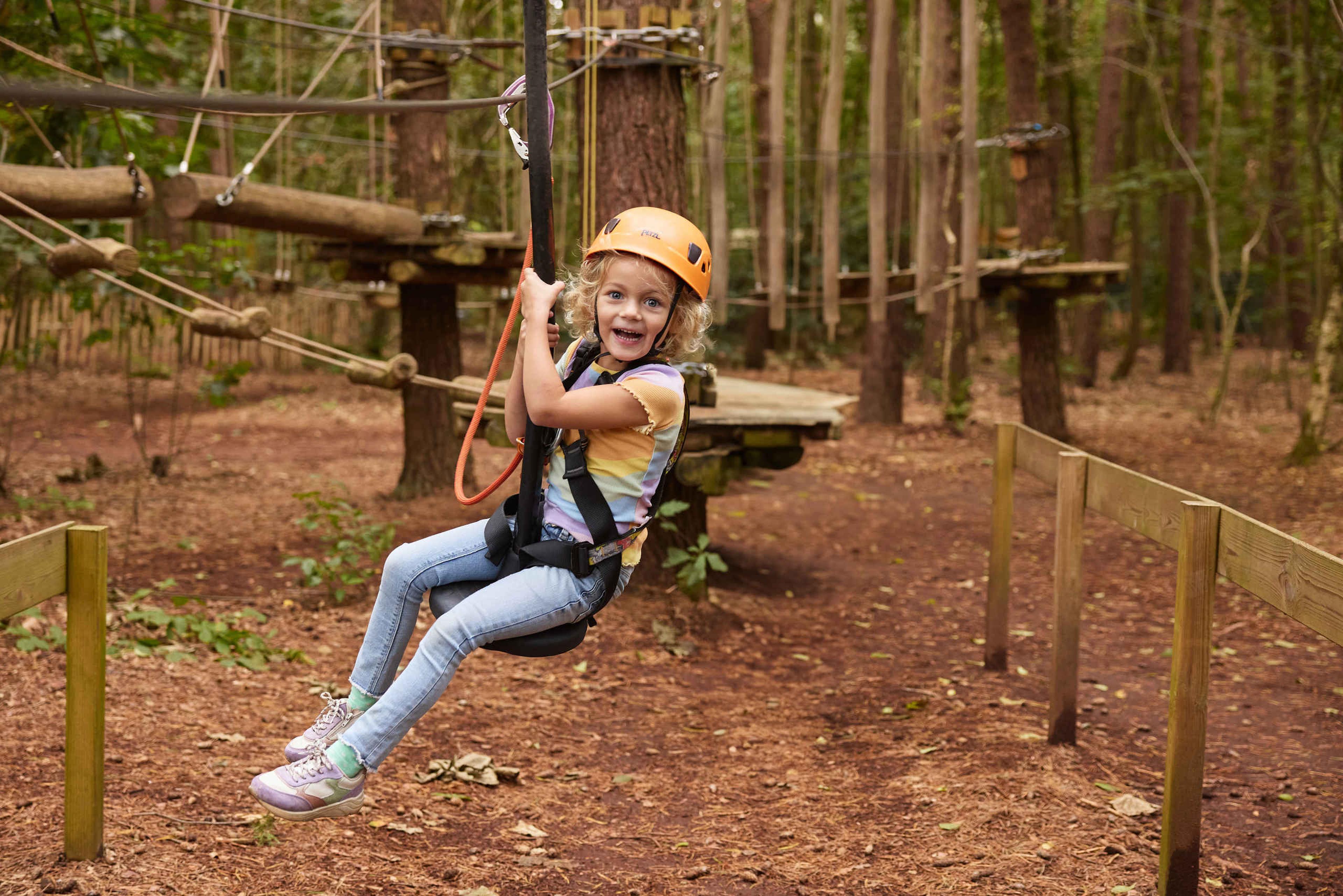 Een meisje gaat van de zipline op het pico parcours bij Klimrijk Brabant.