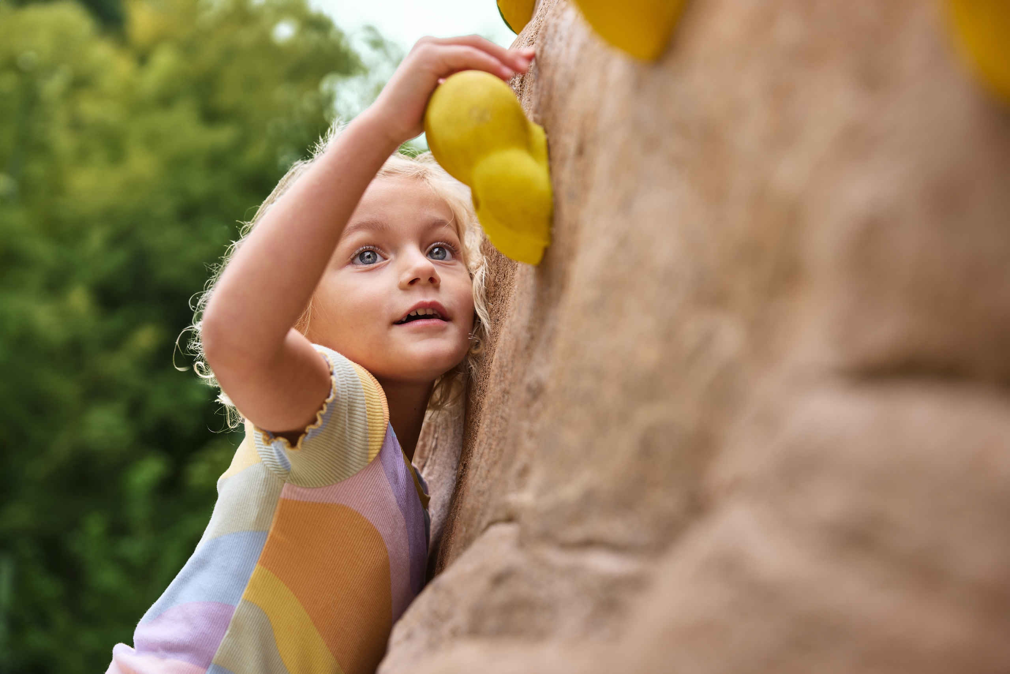 Een meisje klimt op het boulderpark bij Klimrijk Brabant.