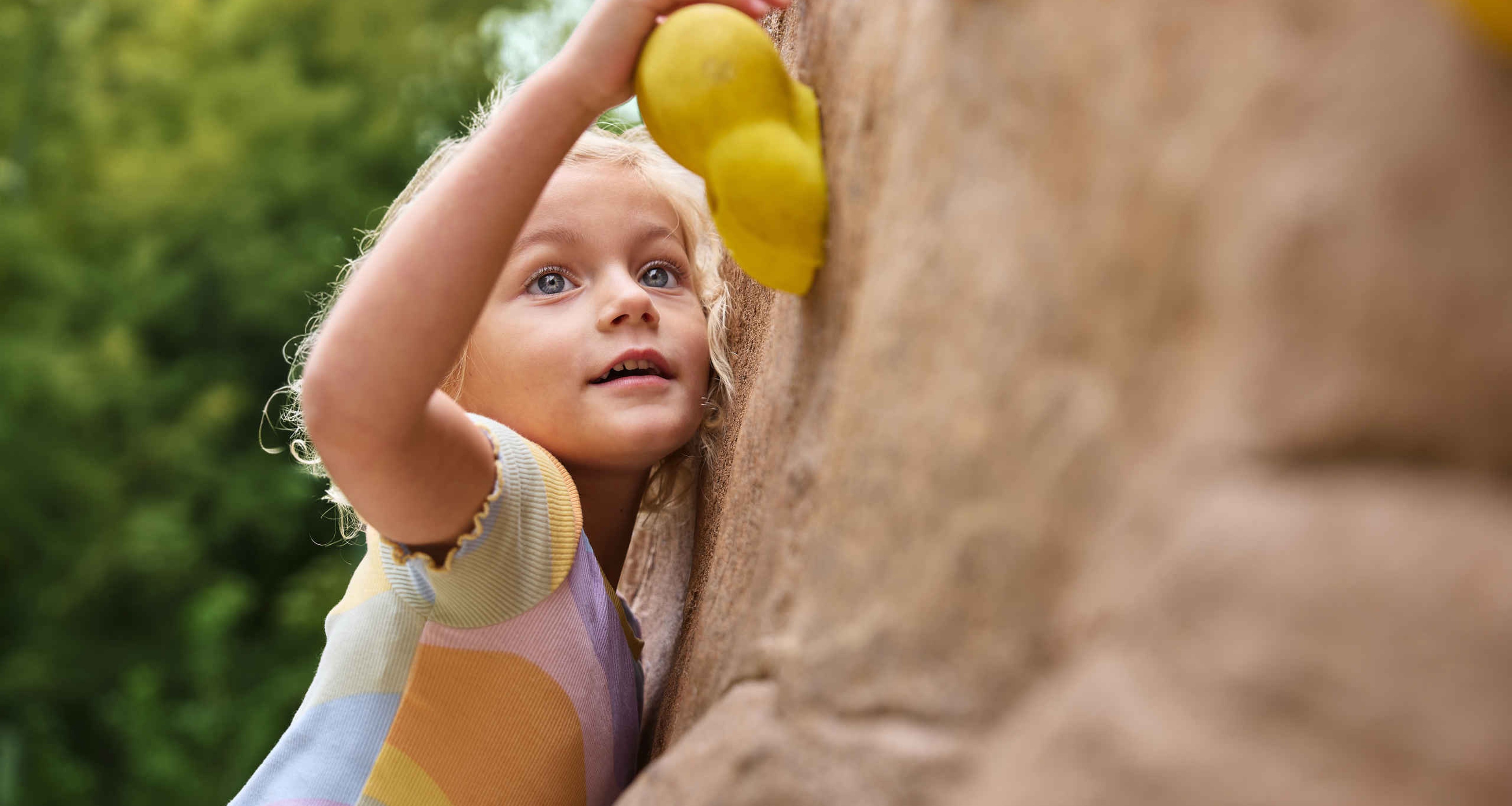 Een meisje klimt op het boulderpark bij Klimrijk Brabant.