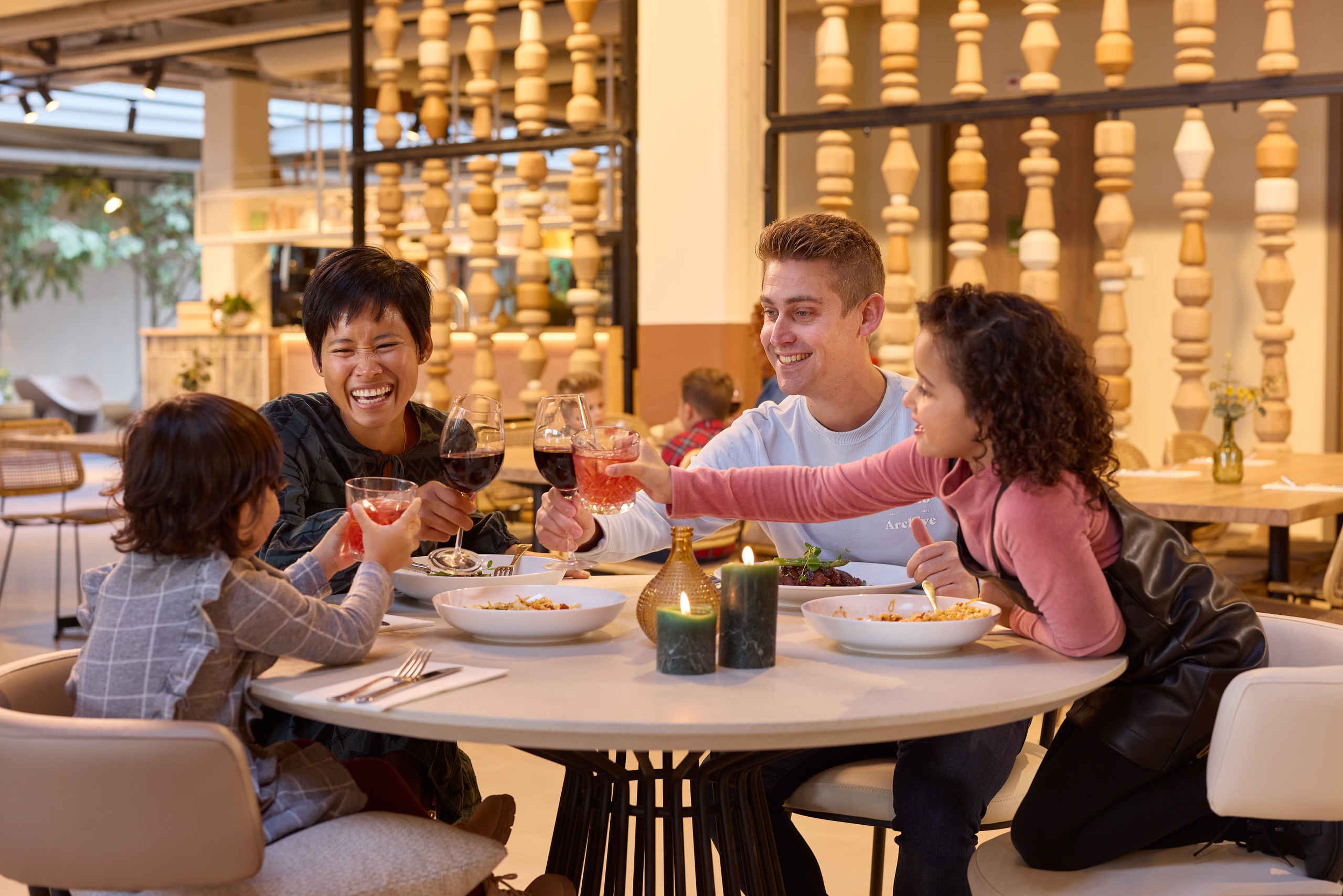 Een gezin proost bij restaurant Labadi op Lake Resort Beekse Bergen.
