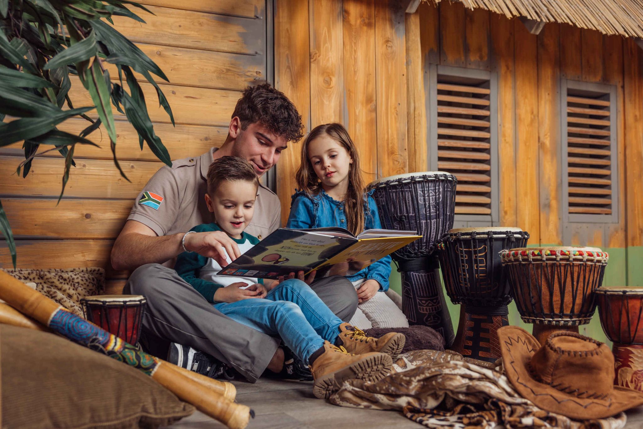 Ranger en kinderen lezen een boek tijdens de animatie in Kodidi Ground bij Lake Resort Beekse Bergen