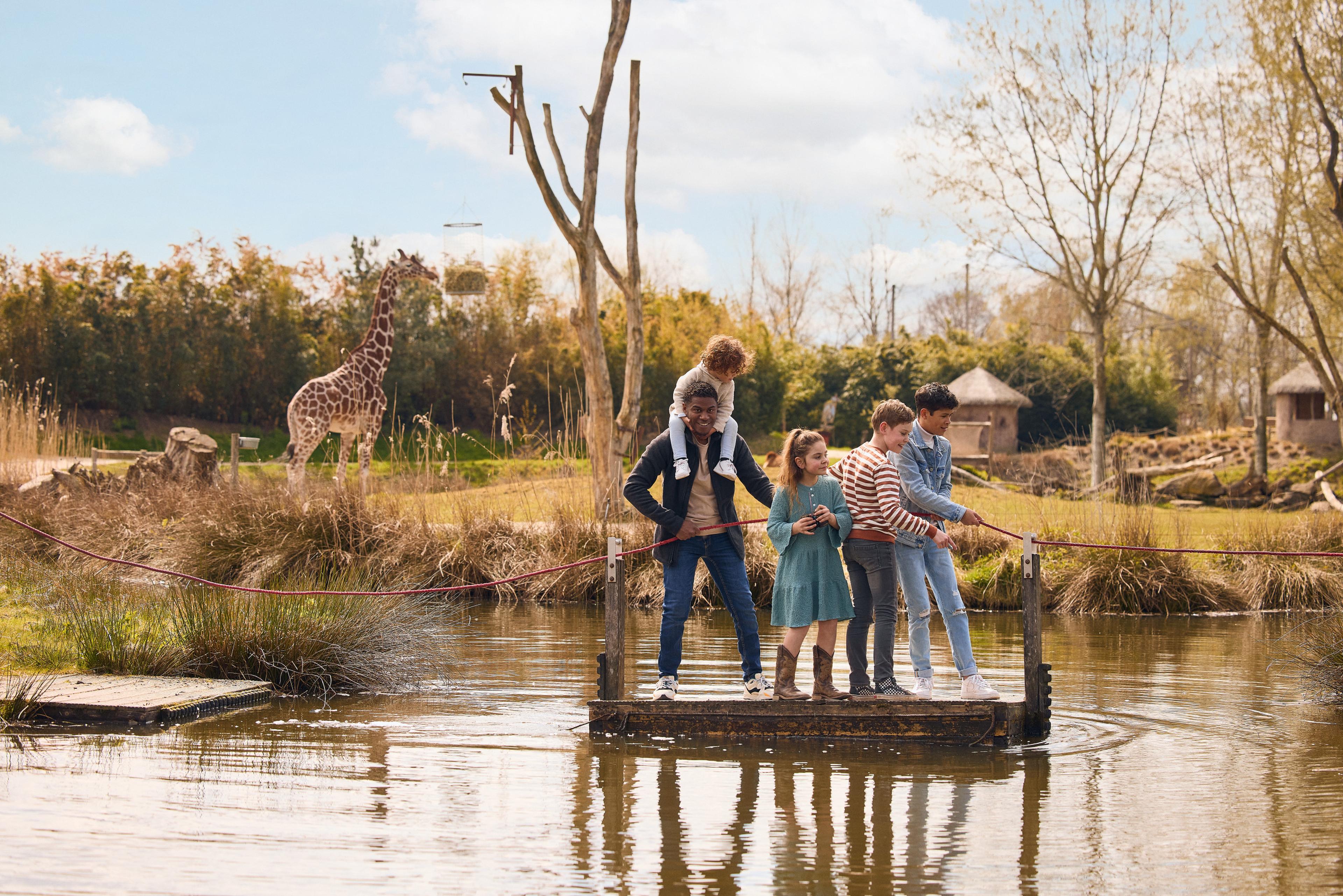 Kinderen op vlot in het water bij de giraffen in ZooParc Overloon