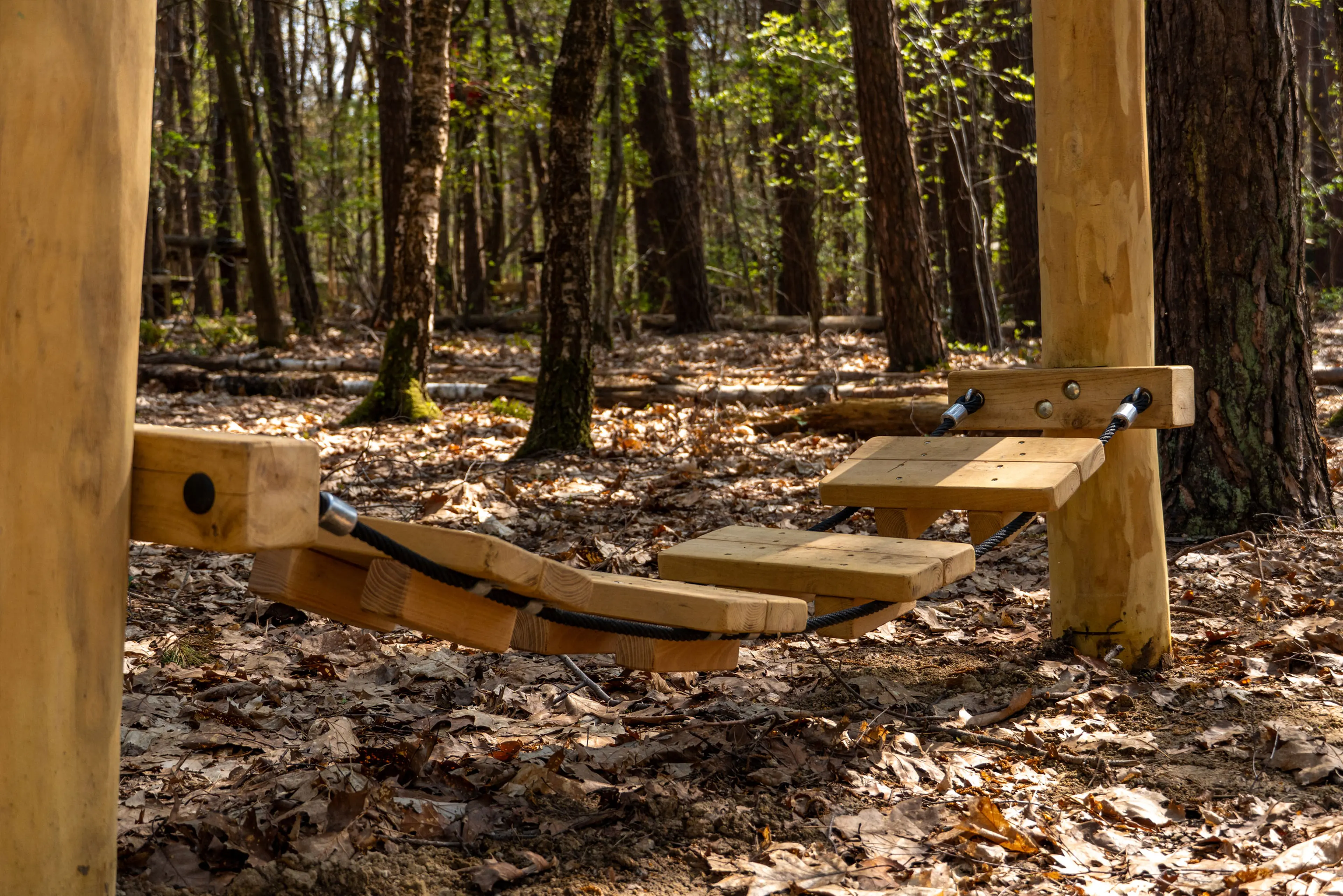 Een houten brug als een van de hindernissen van het Low Rope Parcours bij Klimrijk Brabant