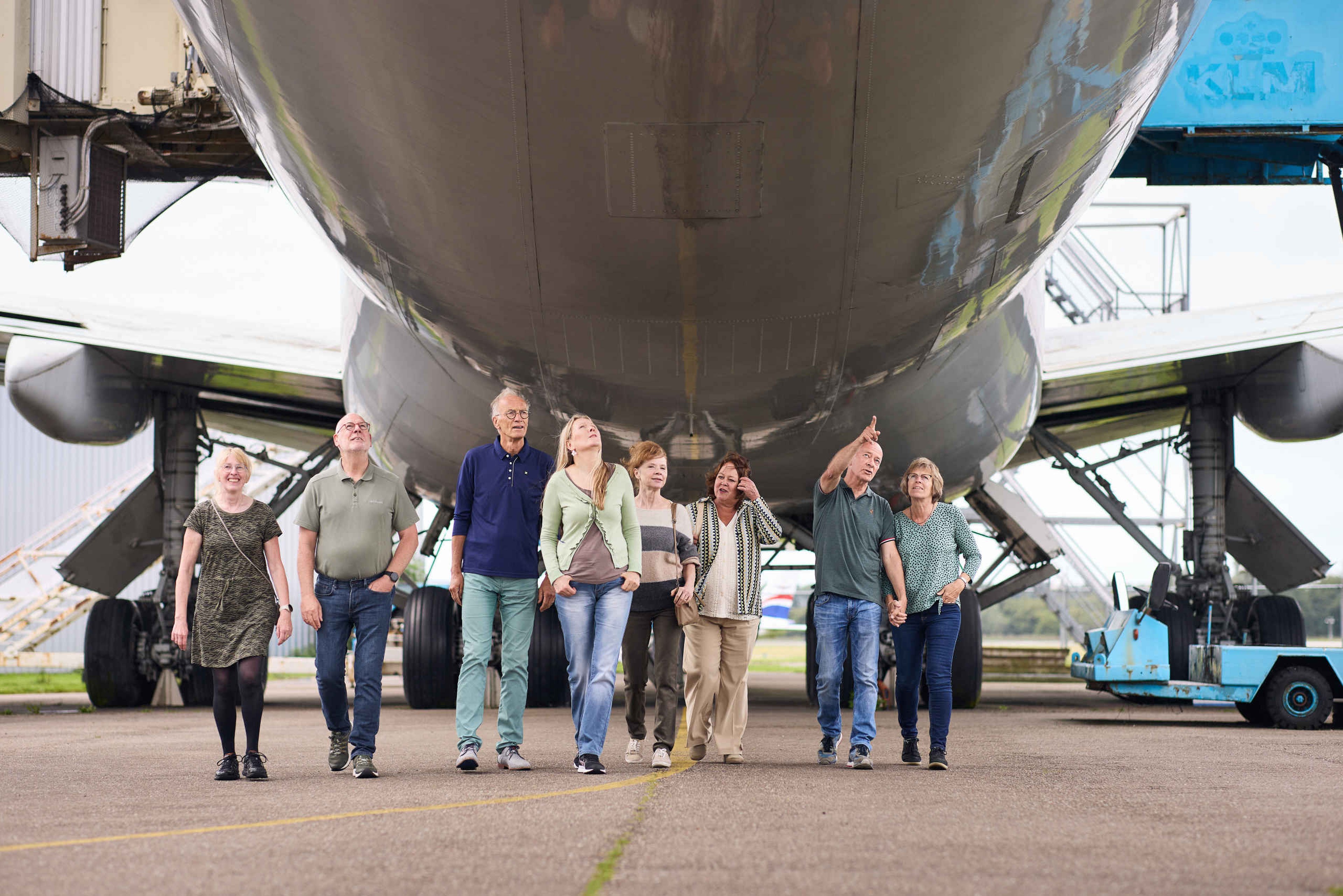 Zorginstellingen senioren lopen onder vliegtuig in Luchtvaartmuseum Aviodrome