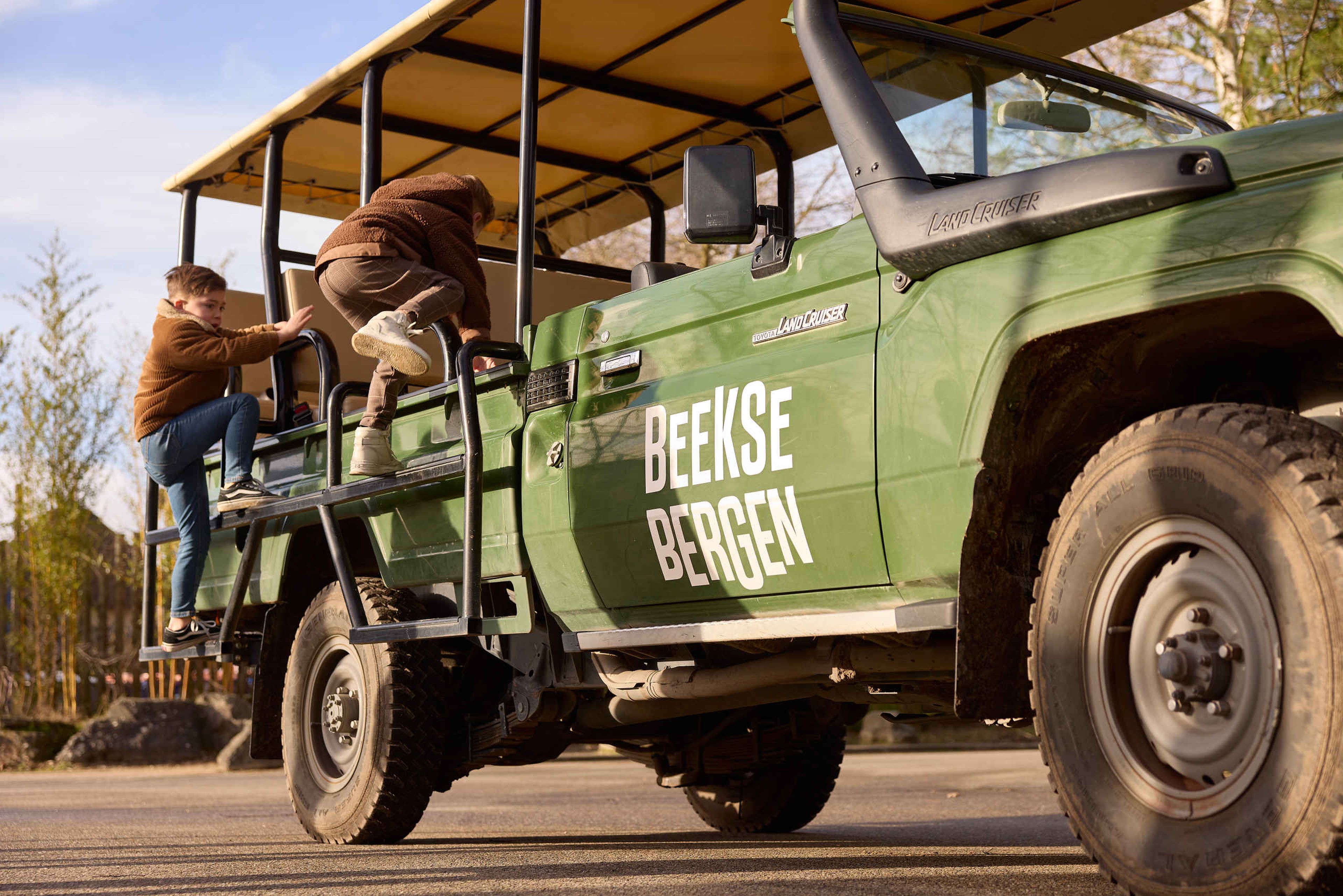 Winter kinderen klimmen in jeep voor Gamedrive Safaripark Beekse Bergen