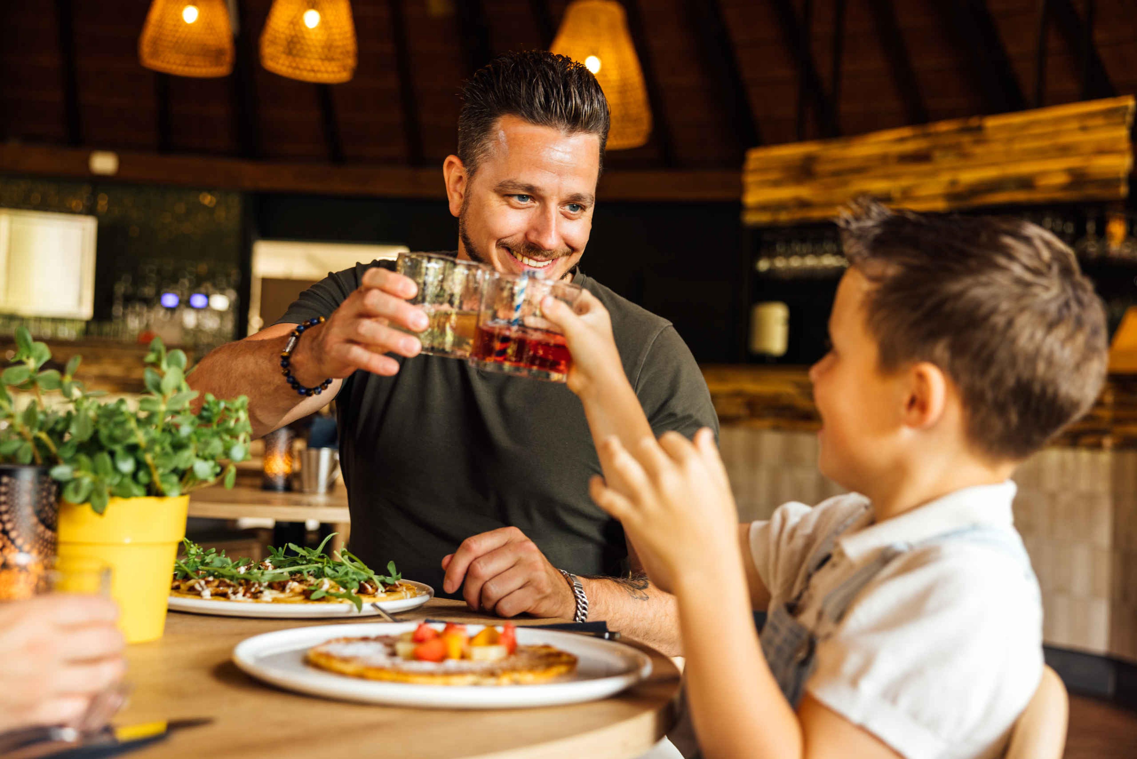 Vader en zoon proosten in pannenkoeken restaurant Wanyama in Safaripark Beekse Bergen