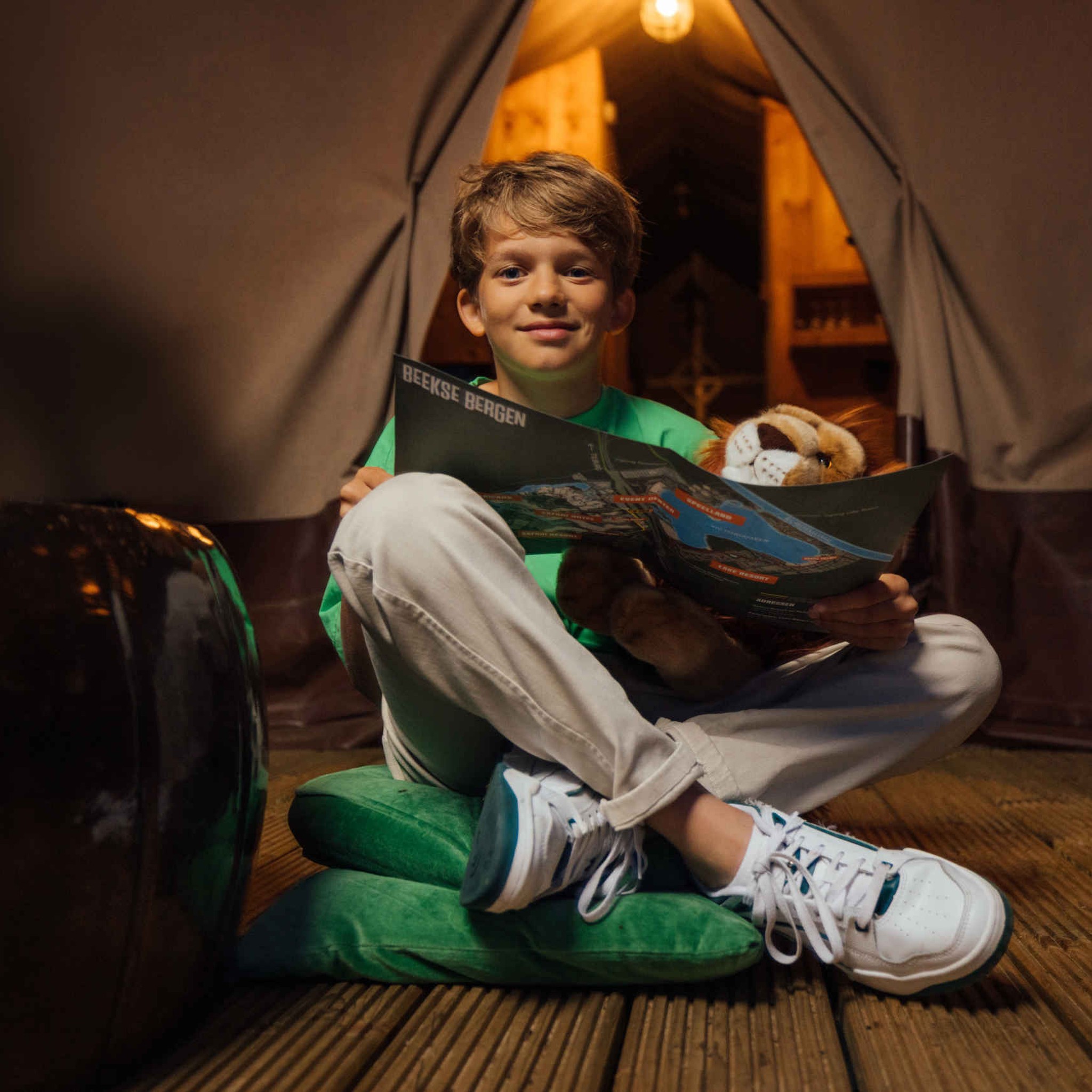 Jongen met plattegrond bij tent in Lake Resort Beekse Bergen