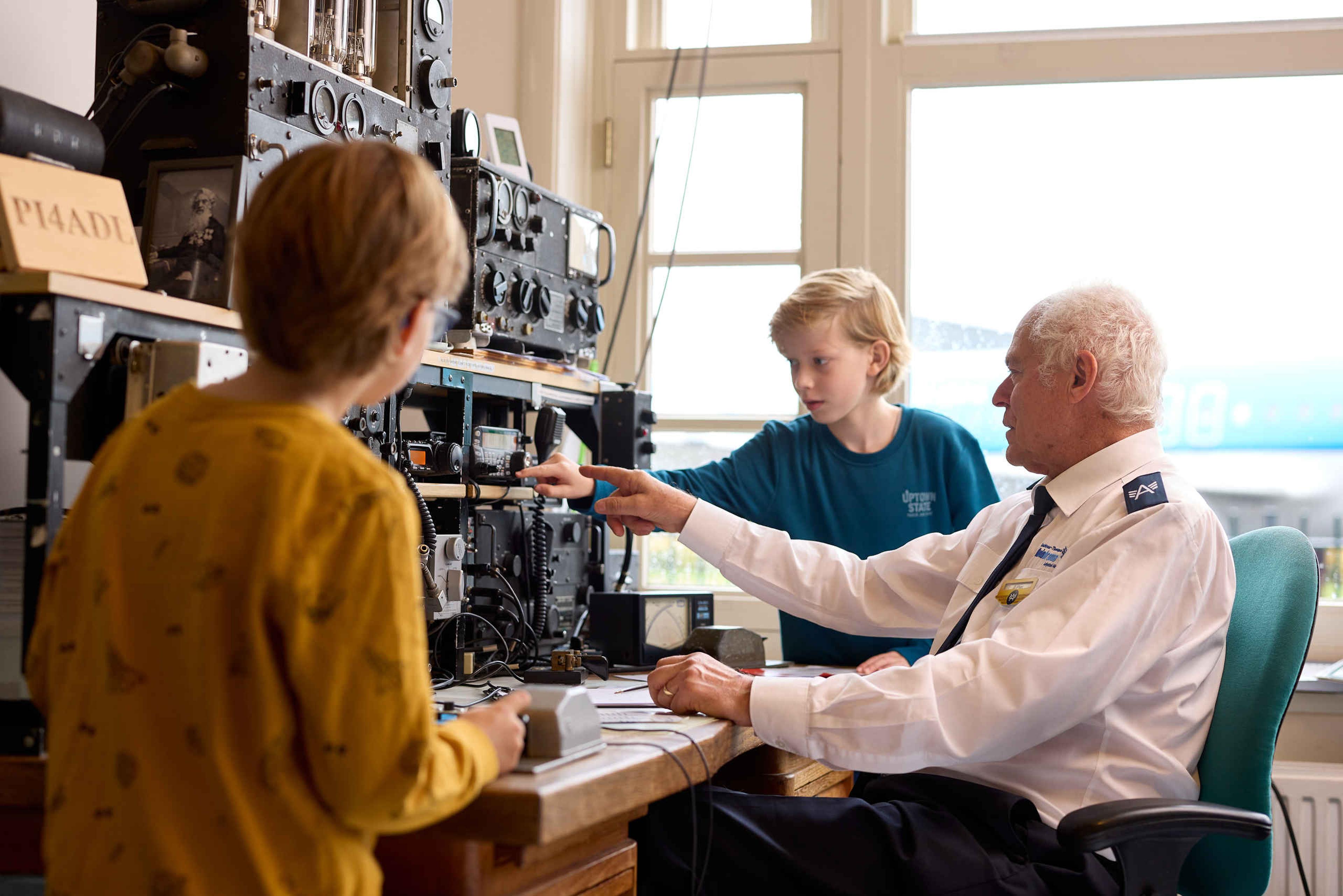 Vrijwilliger geeft uitleg aan kinderen in Luchtvaartmuseum Aviodrome