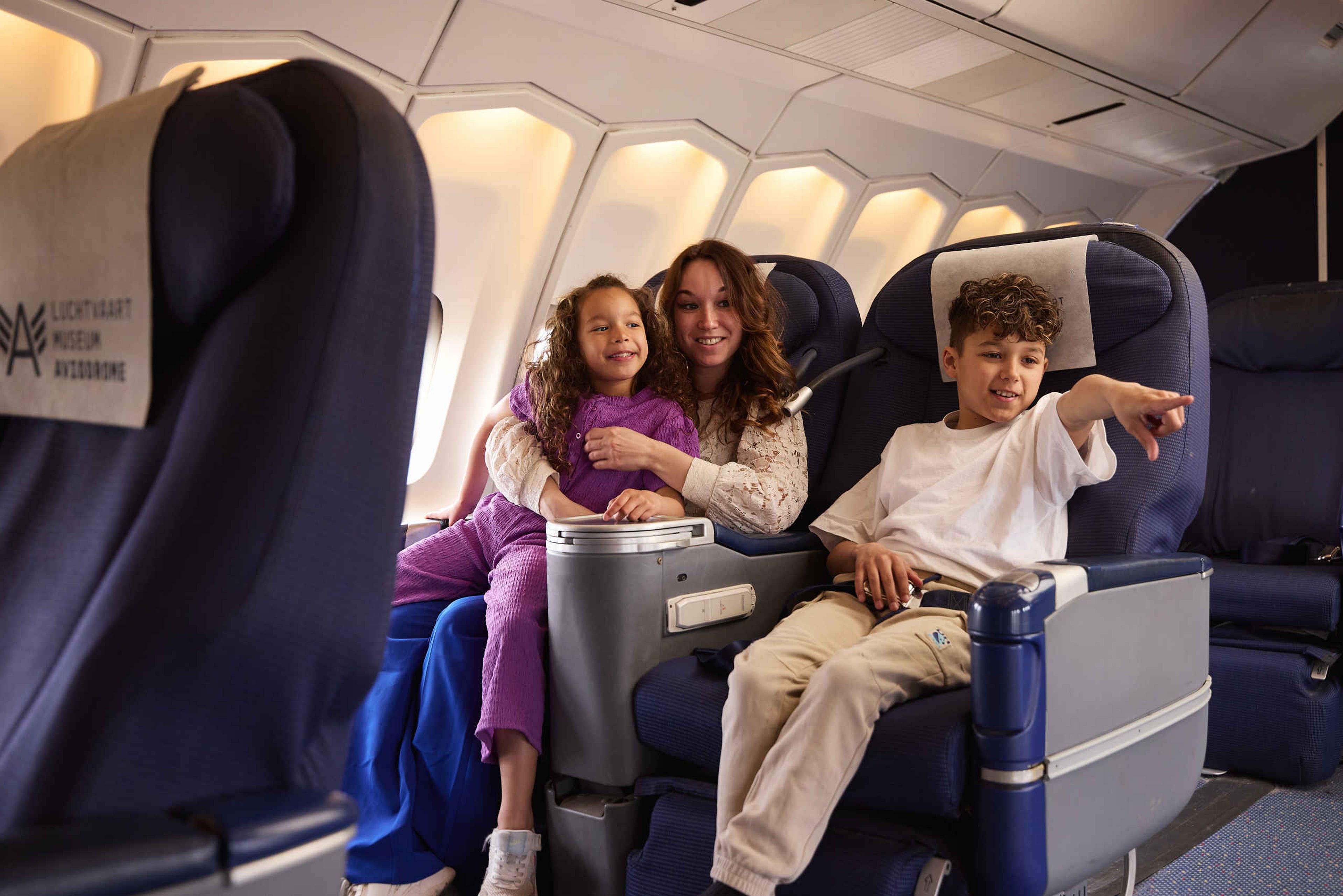 Gezin met kinderen in vliegtuig als passagier in Luchtvaartmuseum Aviodrome