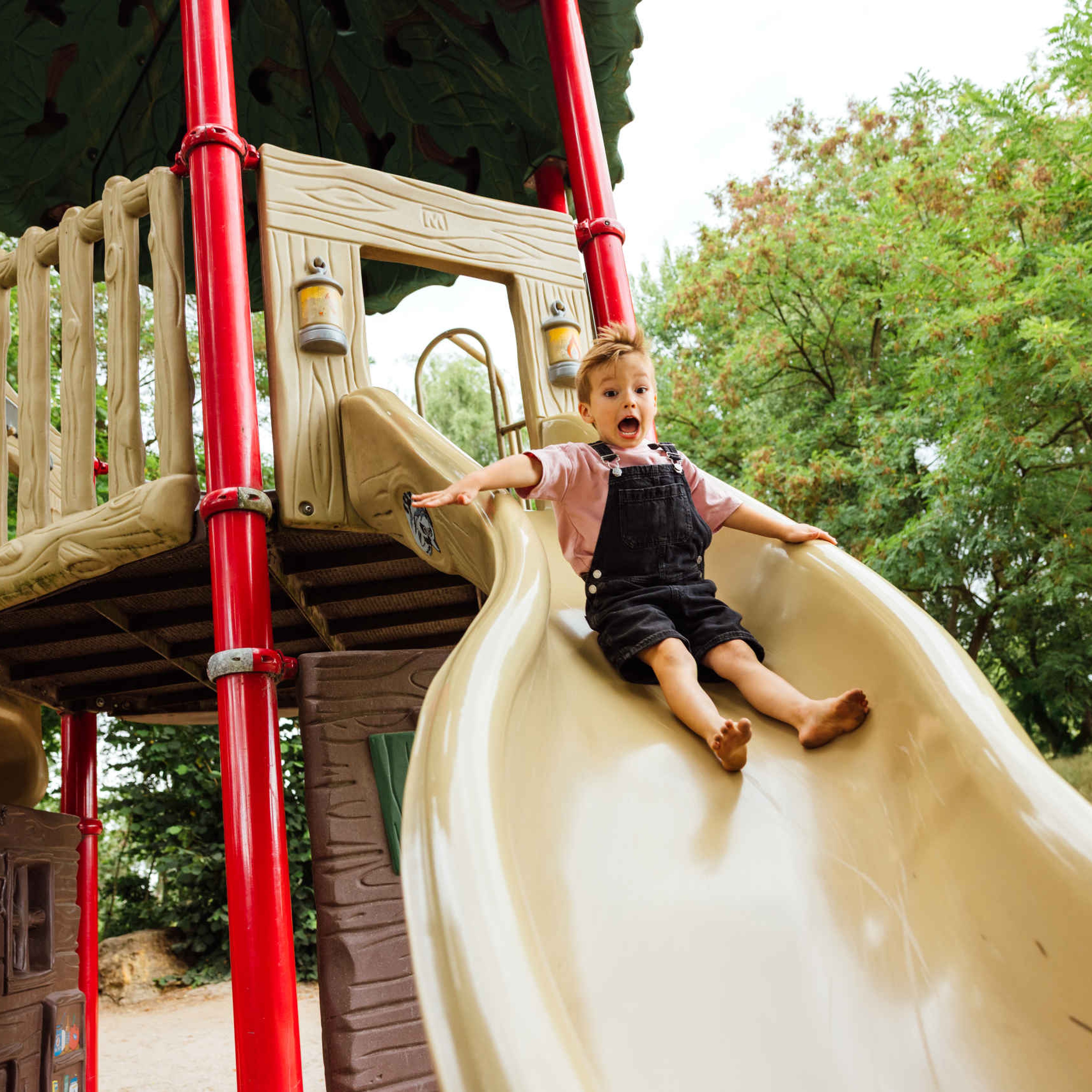In de zomer glijdt een jongen van de glijbaan in Safaripark Beekse Bergen