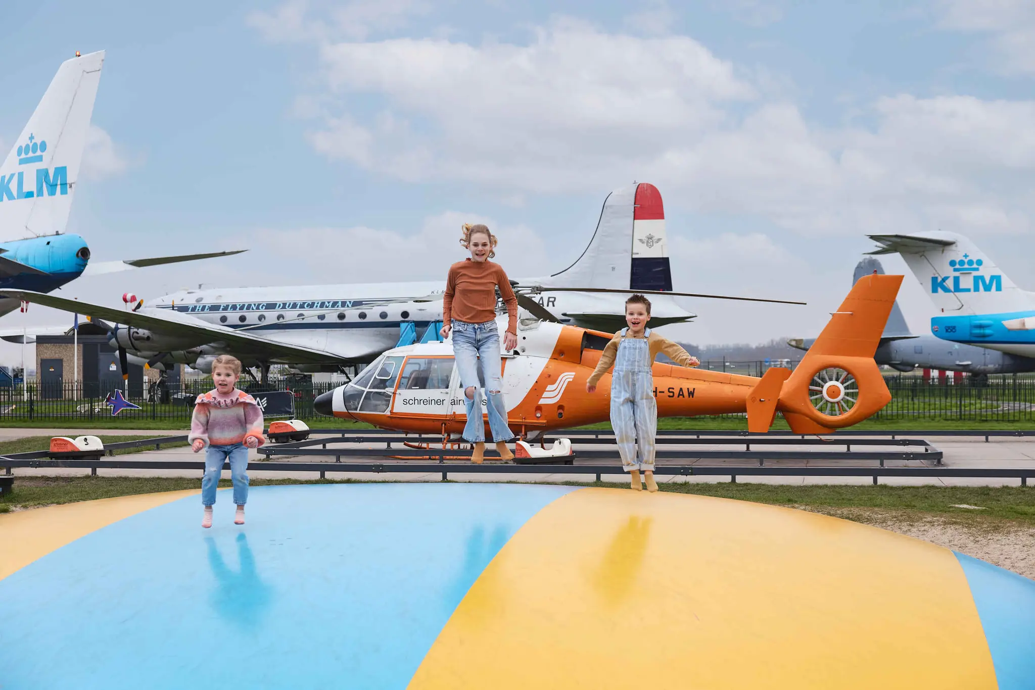 Kinderen spelen en springen op springkussen voor vliegtuig najaar Luchtvaarmuseum Aviodrome