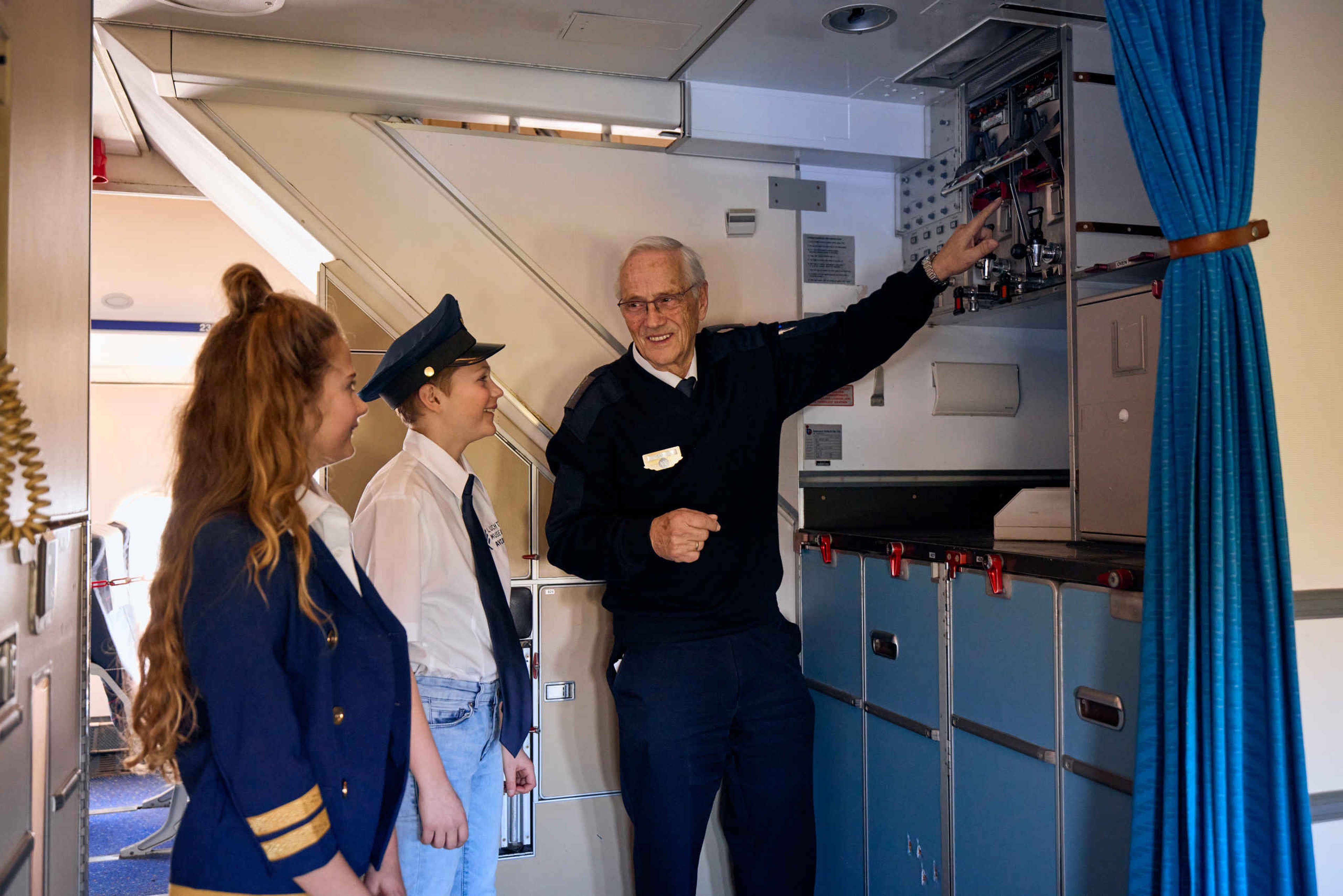 Kinderen krijgen uitleg van een vrijwilliger over het eten en drinken in de boeing 747bij Luchtvaartmuseum Aviodrome