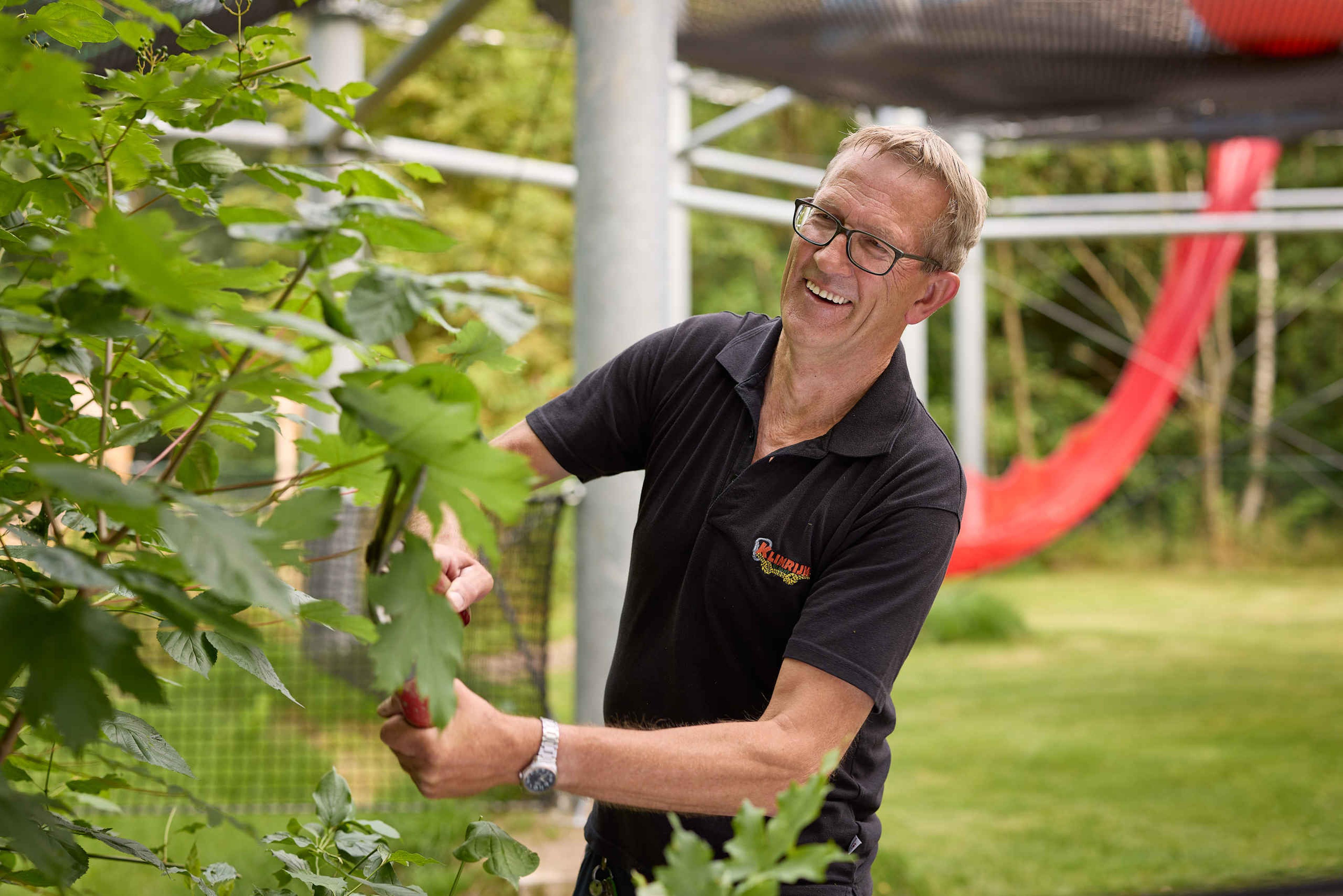 Een medewerker van Klimrijk bezig met de groenvoorzieningen