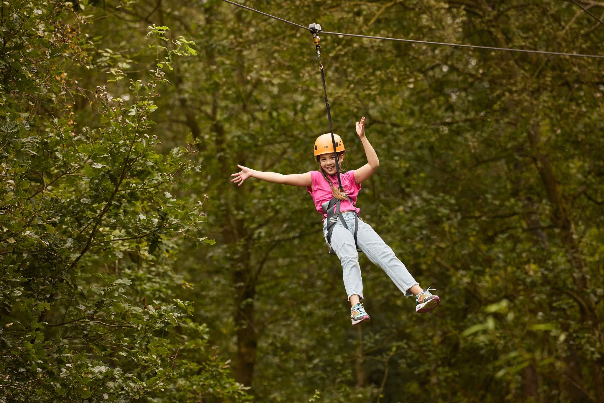 Een meisje gaat van de zipline op het klimparcours bij Klimrijk Brabant.