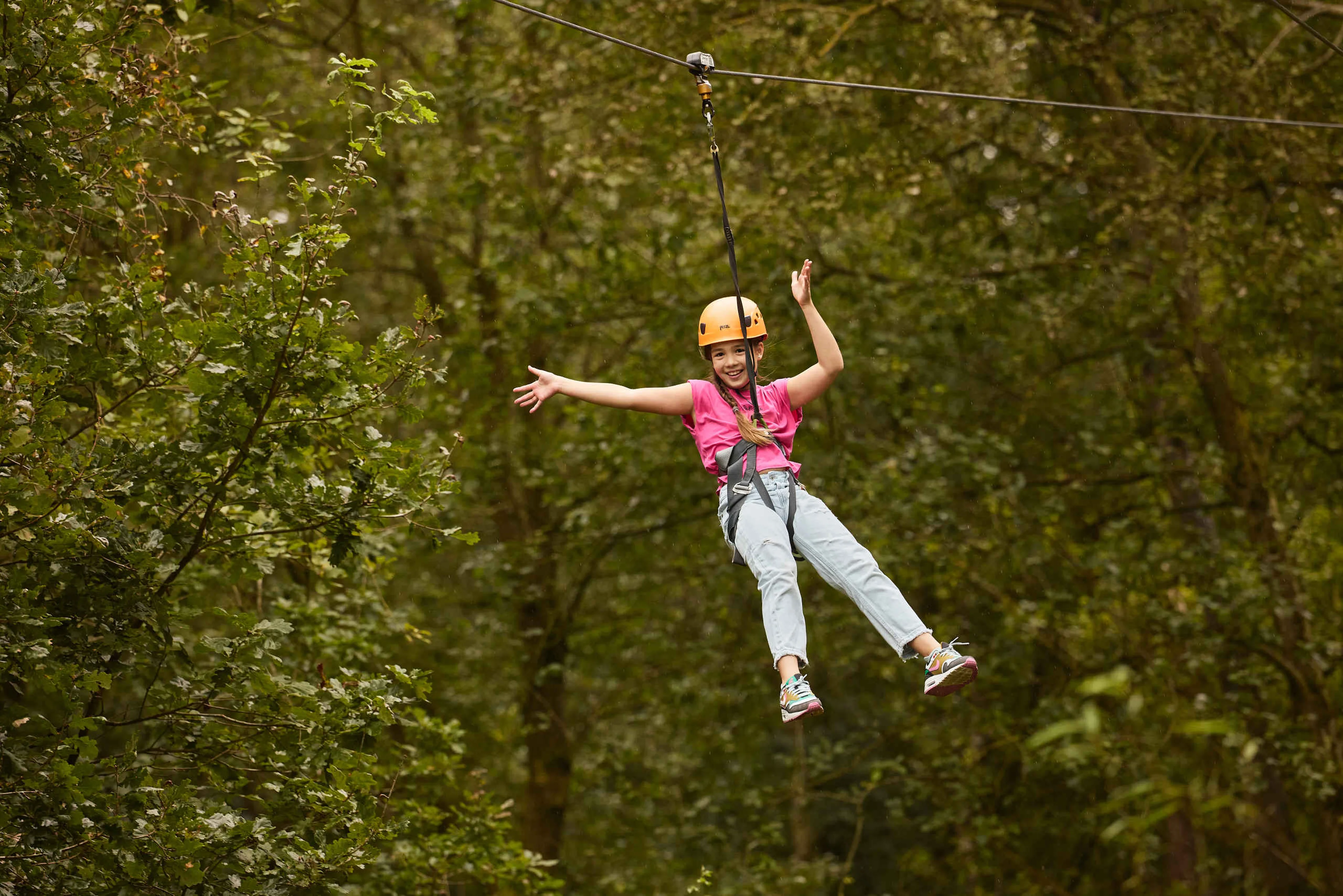 Een meisje gaat van de zipline op het klimparcours bij Klimrijk Brabant.
