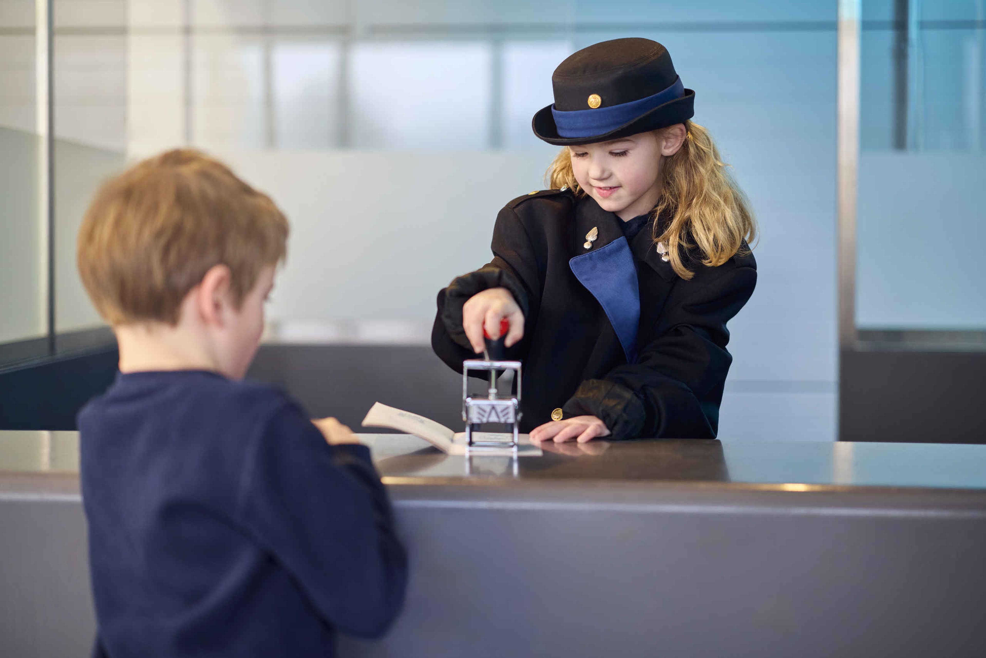 Een jongen en meisje bij de paspoortcontrole tijdens de beroepenweken bij Luchtvaartmuseum Aviodrome