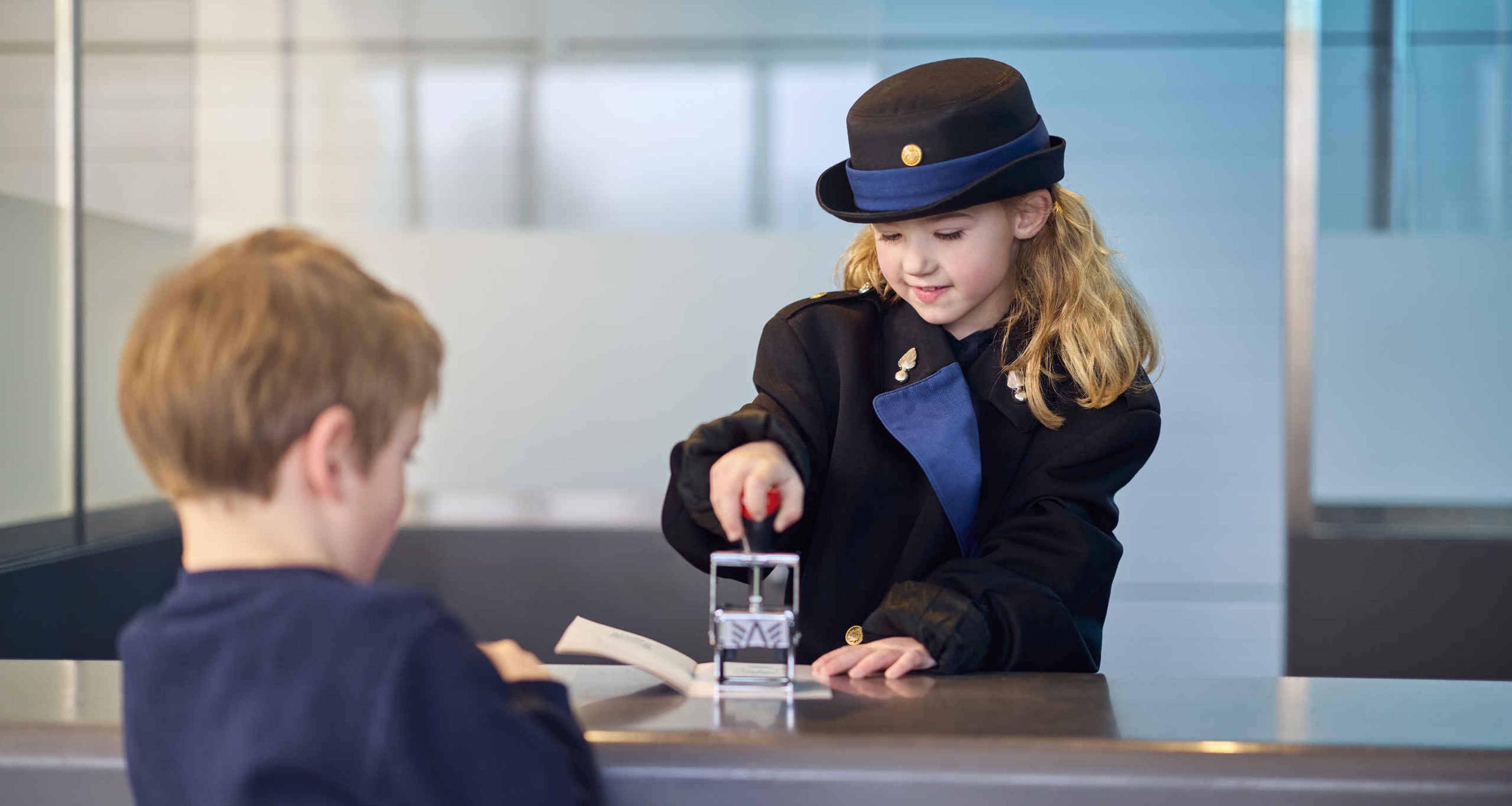 Een jongen en meisje bij de paspoortcontrole tijdens de beroepenweken bij Luchtvaartmuseum Aviodrome