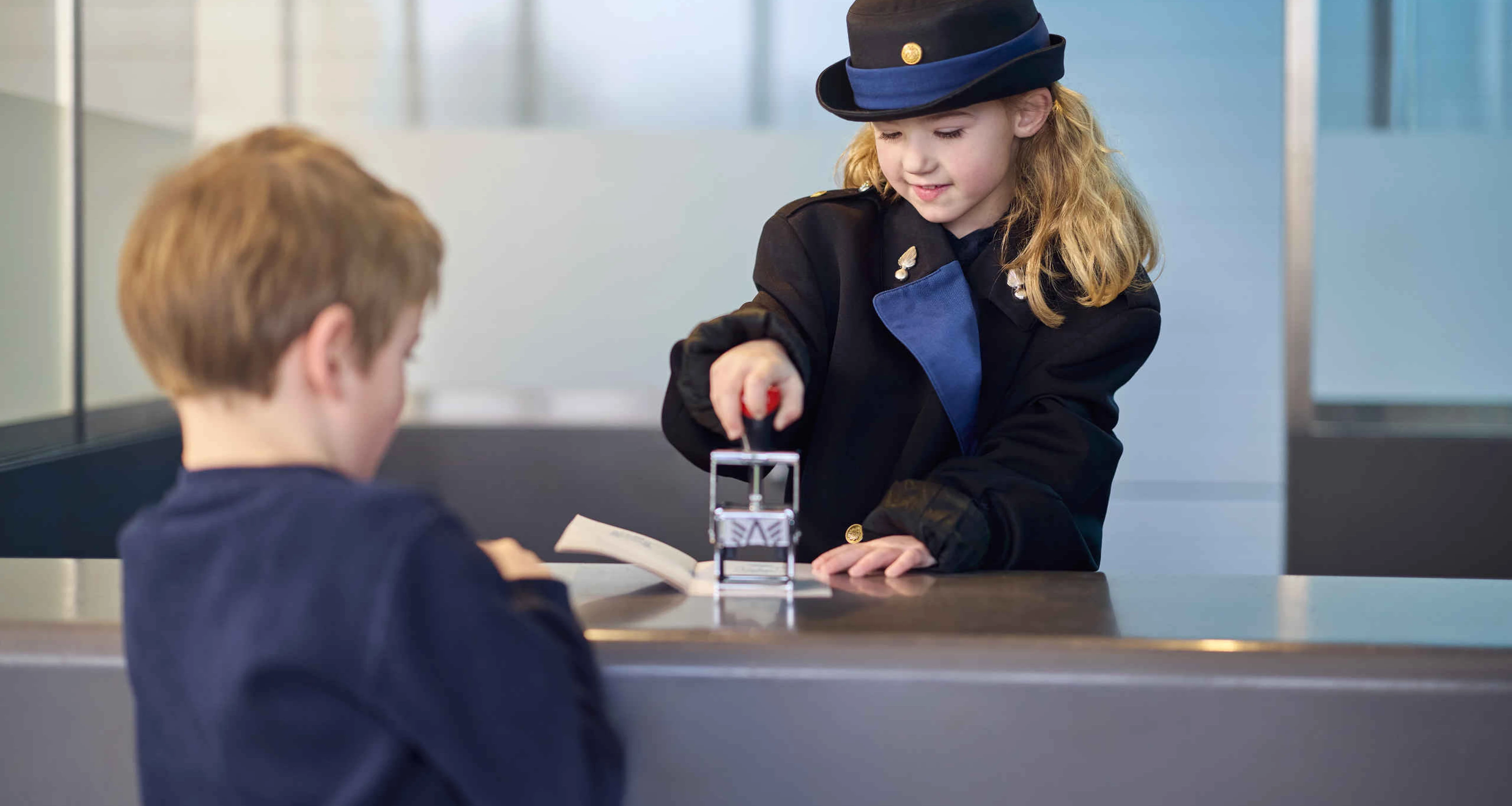 Een jongen en meisje bij de paspoortcontrole tijdens de beroepenweken bij Luchtvaartmuseum Aviodrome